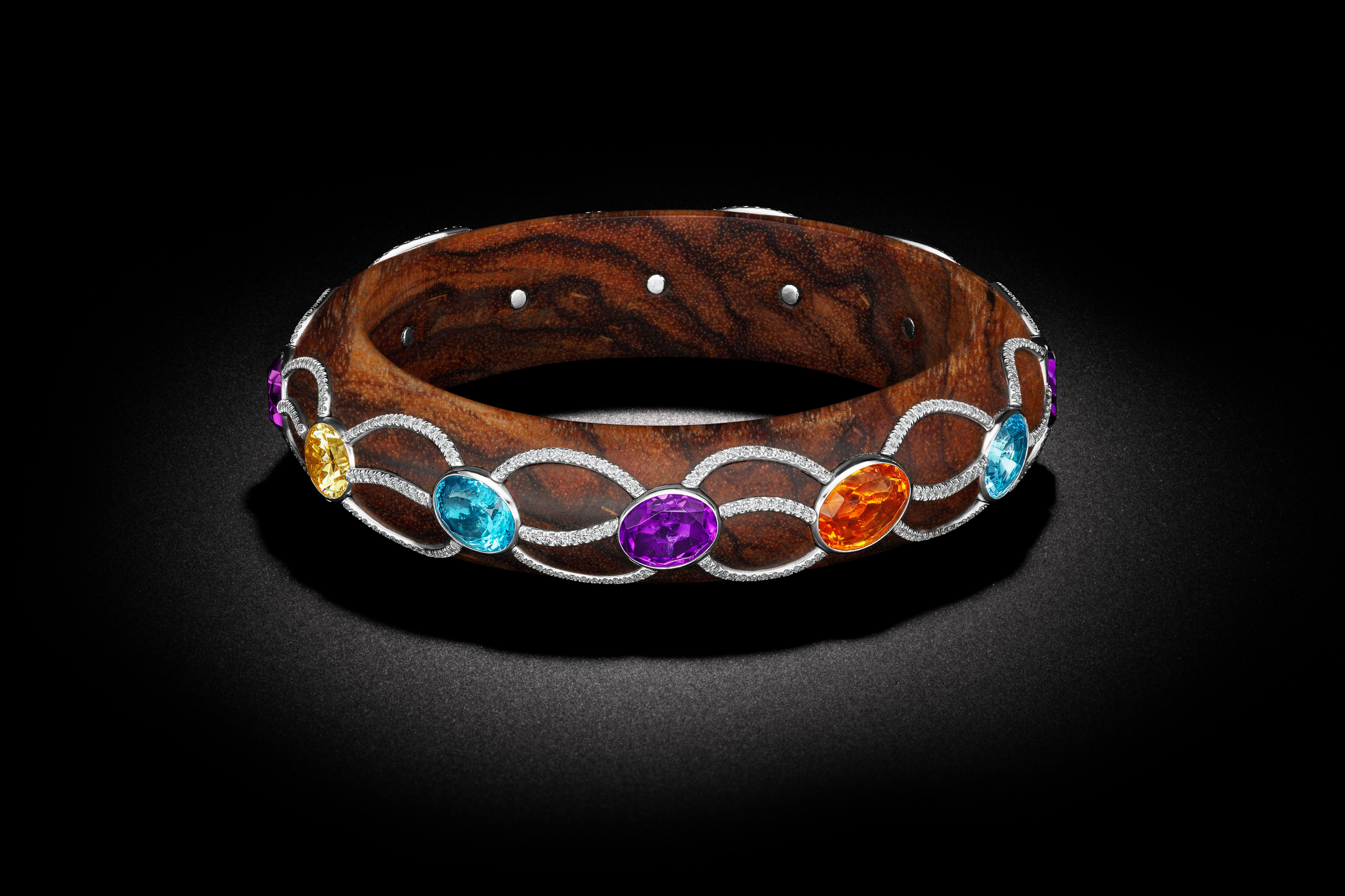 One of kind - wooden bangle. This Begem is covered with multi-colored gems weighing 3.70 carats interlaced in an intrinsic design of 2 carats of pave' diamonds all set in 38.65 grams of Platinum. 



