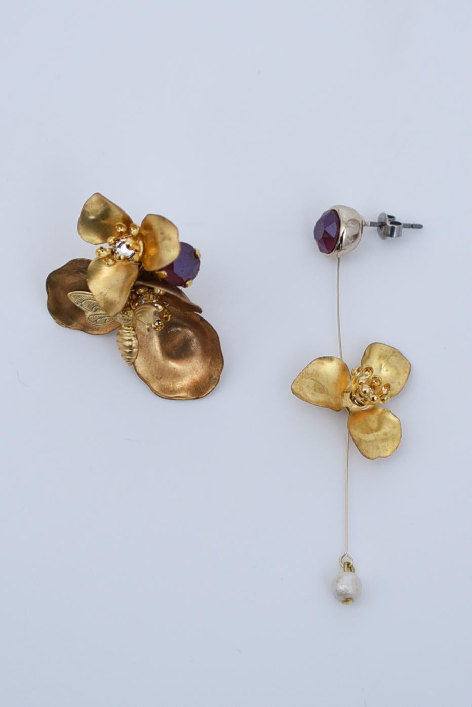 material:wood pearl,1970’s American vintage parts,swarovski,stainless
size:length 6cm

These asymmetrical earrings have one side that rests snugly on the ear and the other side swings in a line.
The line is so delicate that the flowers and pearls