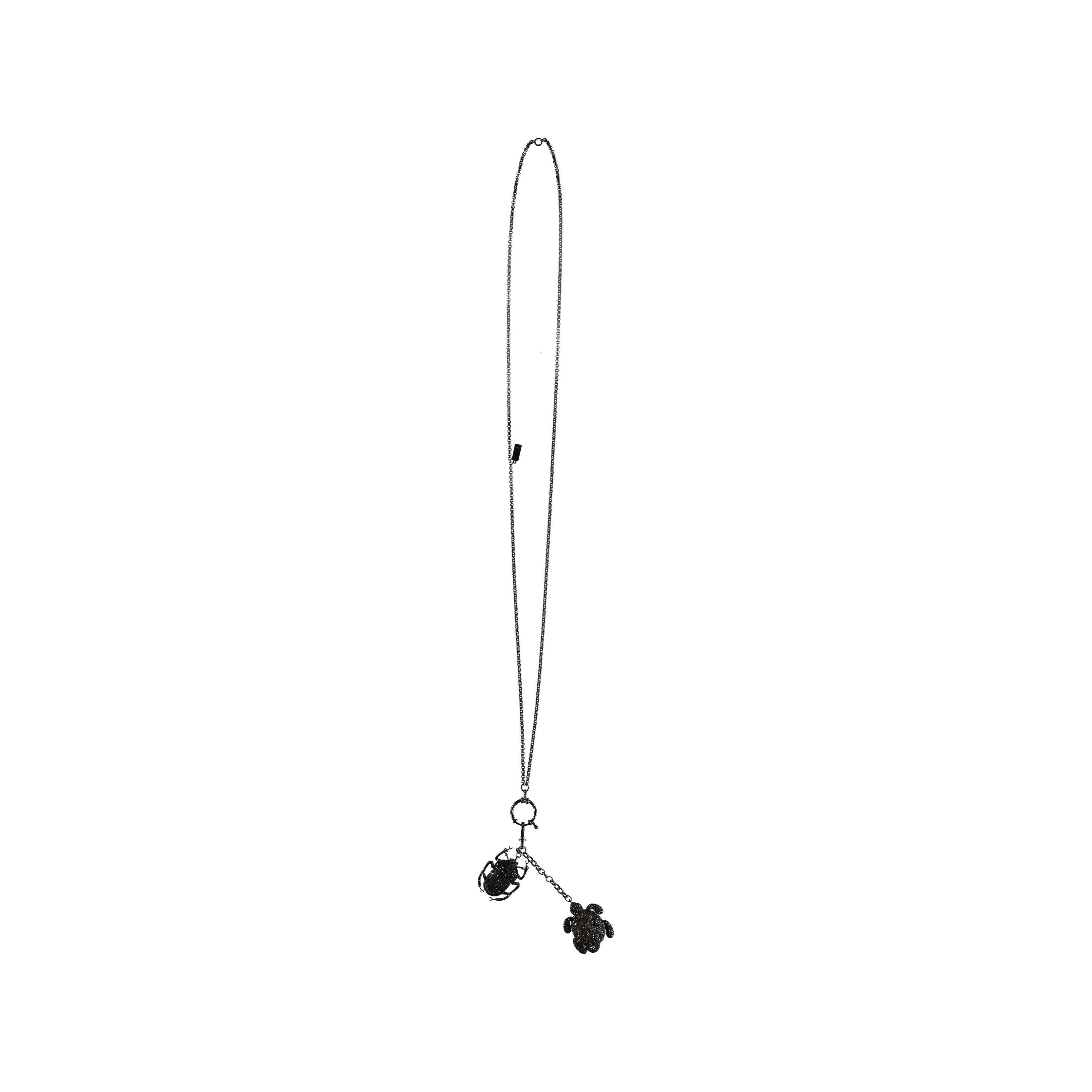 Questa collana Begüm Khan con tartaruga e scarabeo è realizzata in uno stile eccentrico con una placcatura in rutenio. Questo pezzo, che presenta la tecnica tipica del designer di combinare una tartaruga e uno scarabeo in modo giocoso, sarà una
