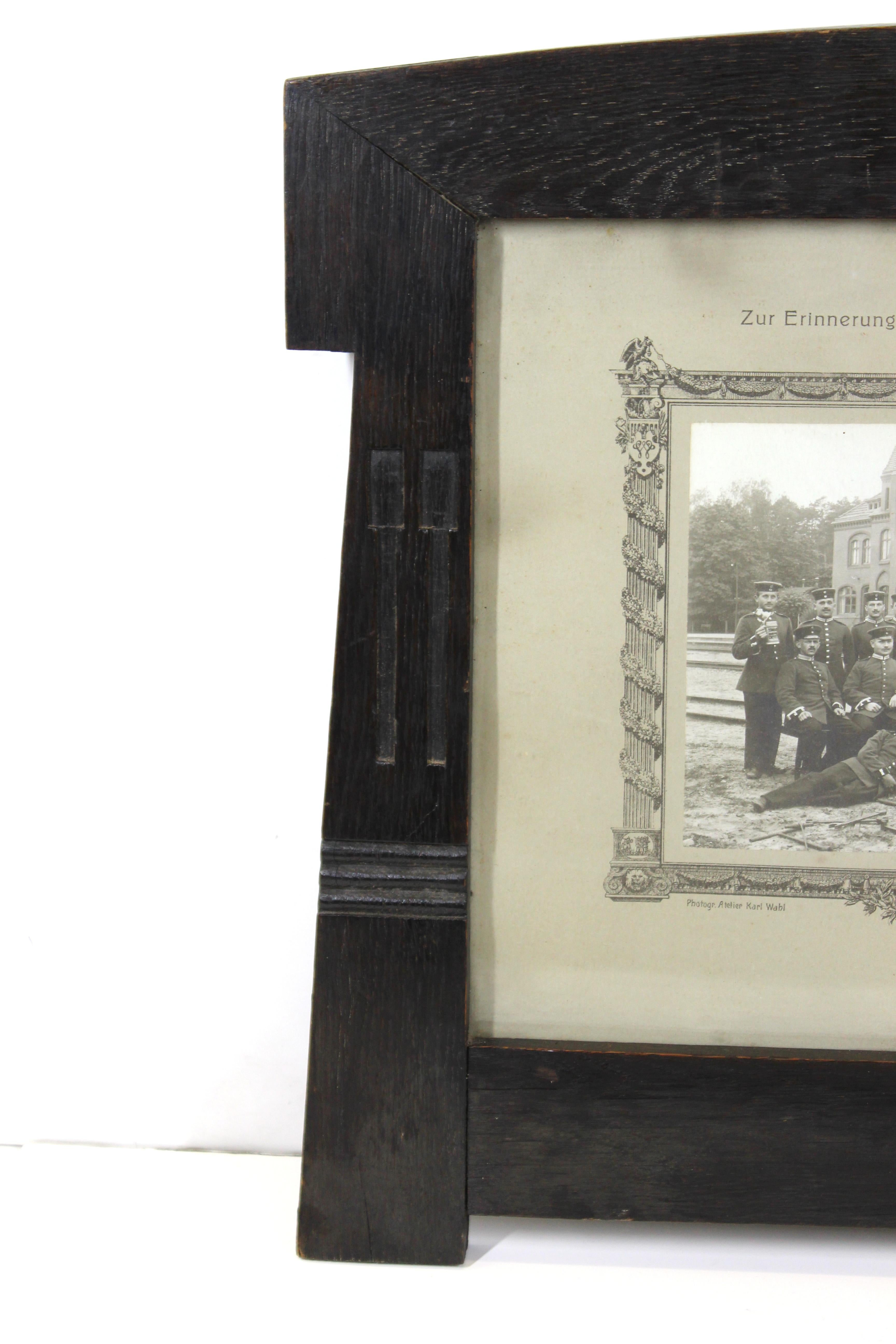 German secessionist carved and ebonized oak picture frame made by a follower of Behrens. The piece was likely made during the 1910s and has an antique photograph of posing German railway workers from circa 1912. In great antique condition with