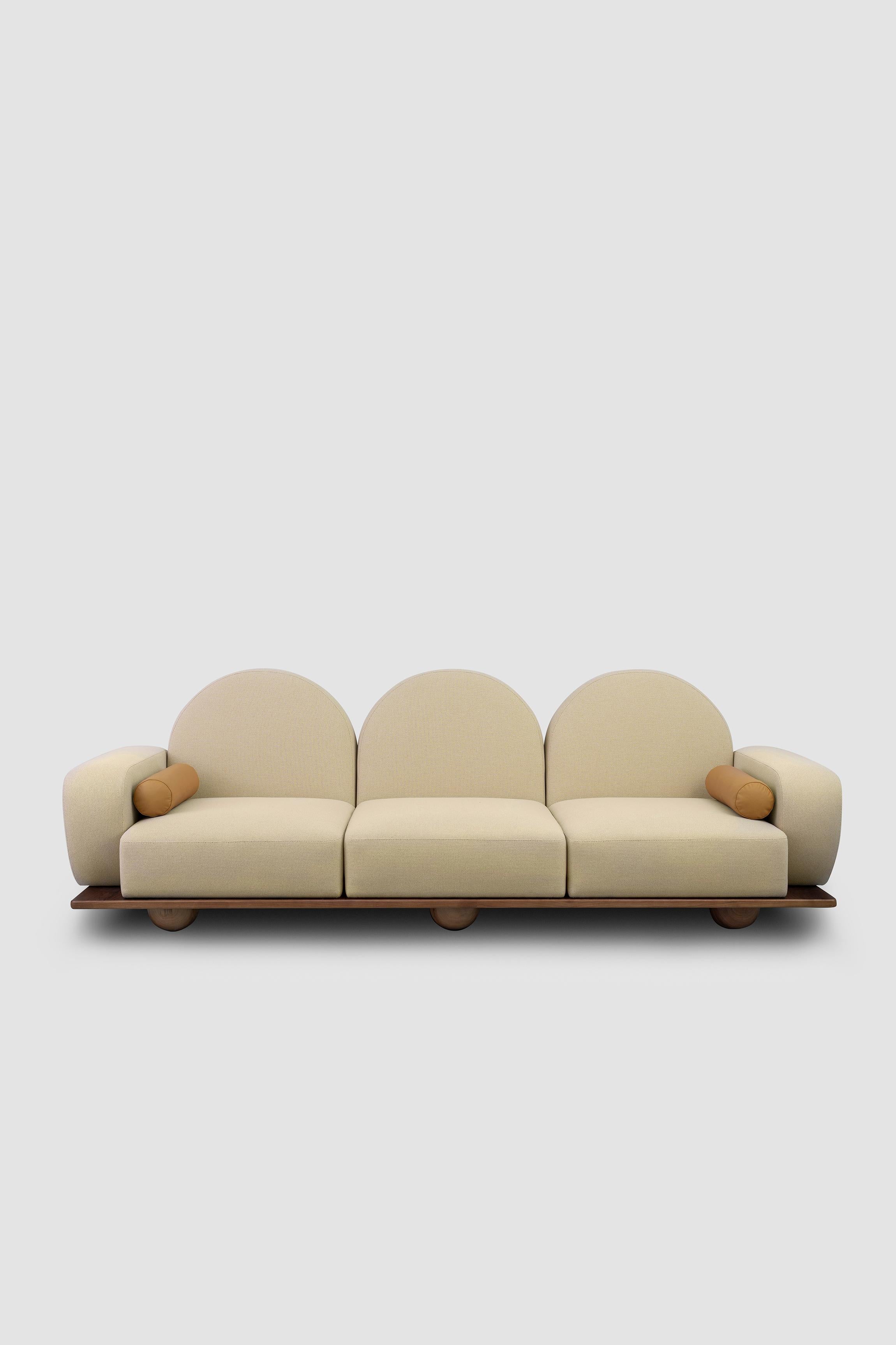 Beice ist ein 3-sitziges Sofa, das das Gefühl vermitteln soll, auf Zuckerwattewolken zu sitzen. Die Kombination aus der Farbe Puderrosa, den bogenförmigen Rückenlehnen, den runden Kanten und den Kugelfüßen aus Nussbaumholz schafft ein verträumtes,