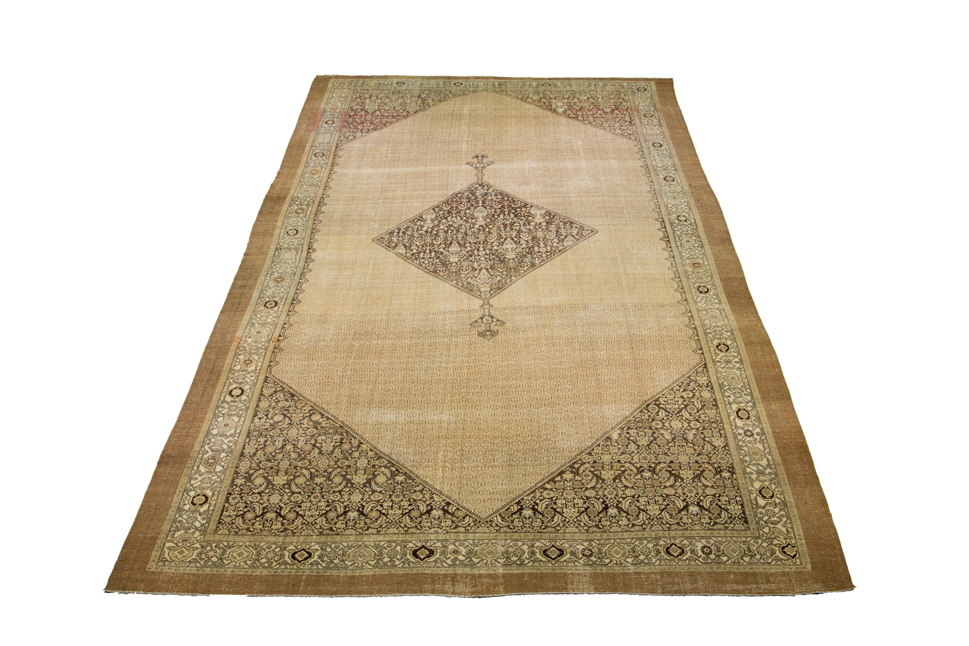 Beautiful antique Persian hand-knotted wool rug with a beige color field. This piece has brown and blue accents in a gorgeous medallion design.

This rug measures 14'3