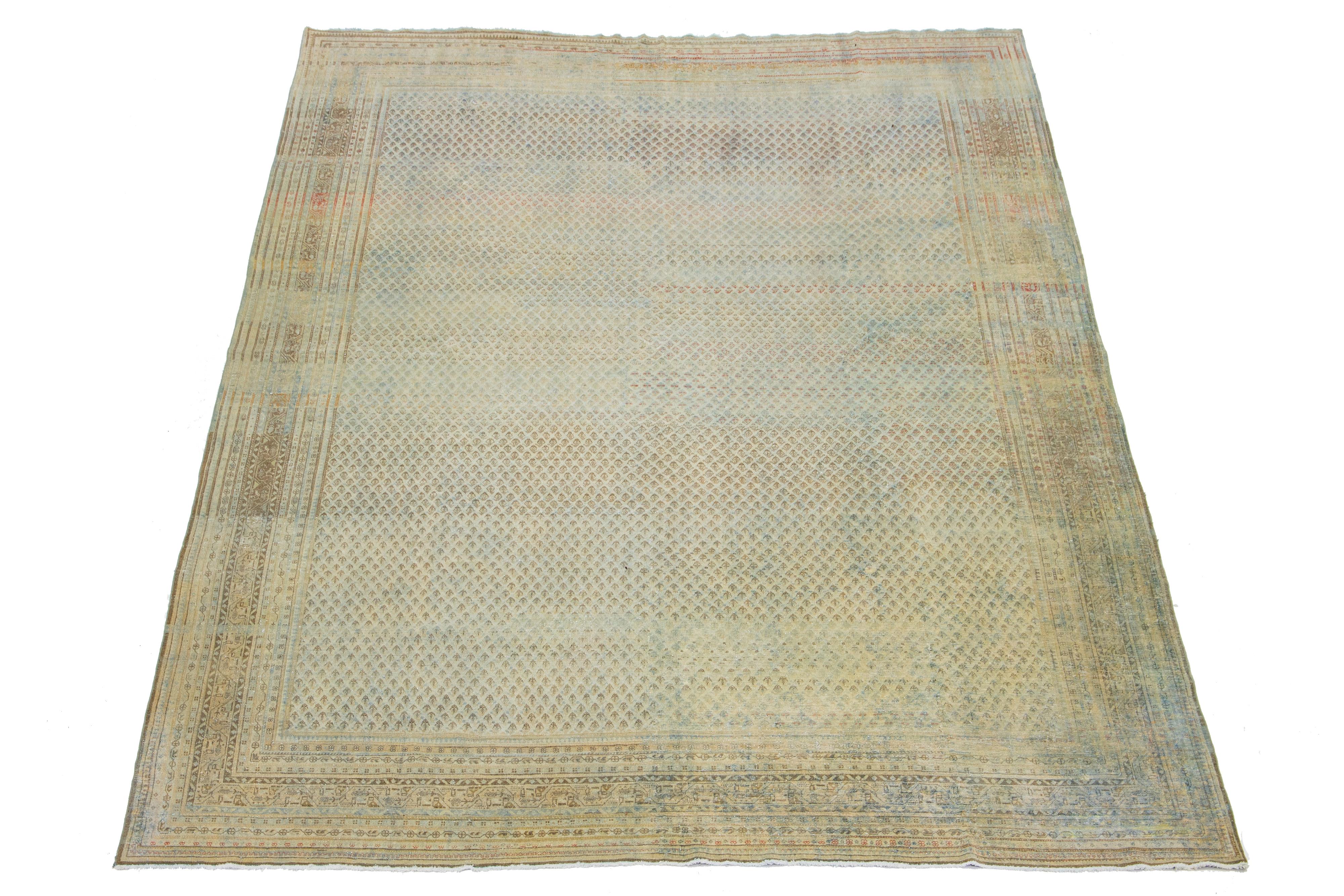 Beautiful room-size antique Malayer hand-knotted wool rug with a beige color field. This Persian rug has a gorgeous all-over design with blue and brown accents.

This rug measures 10'2