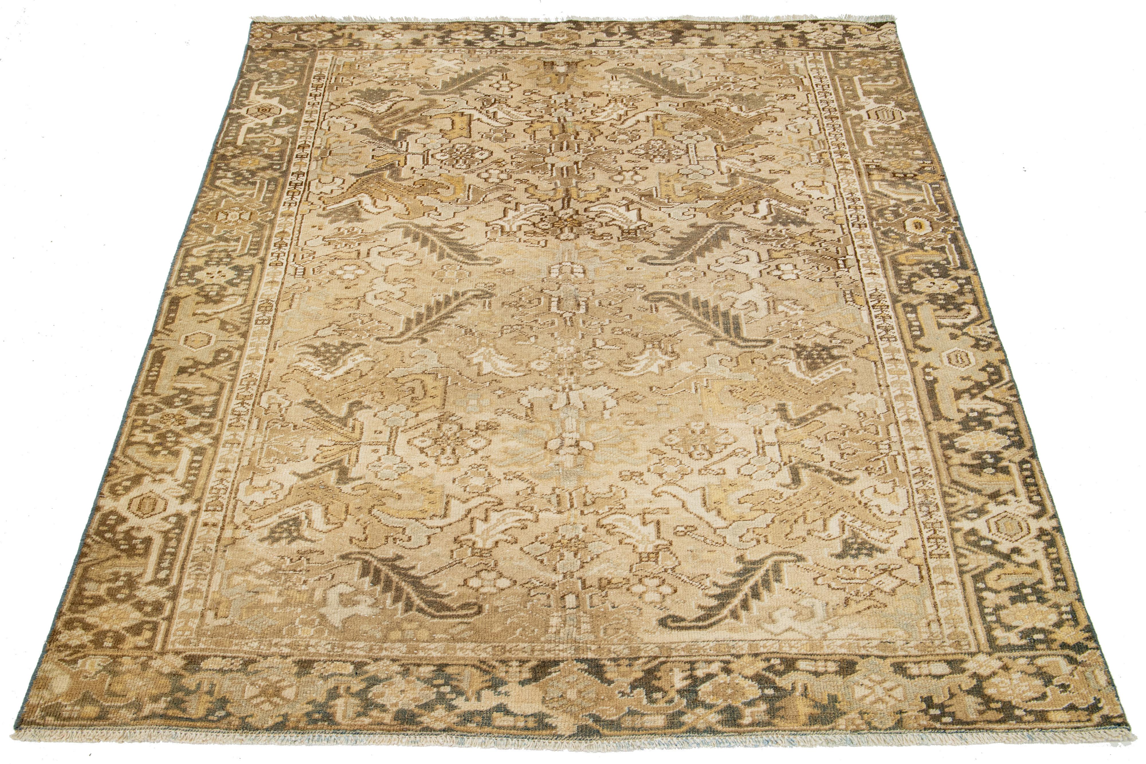 An antique Heriz rug from Persia is hand-knotted using wool. It features a beige field with a blue and brown all-over pattern.

This rug measures 6'4' x 7'10