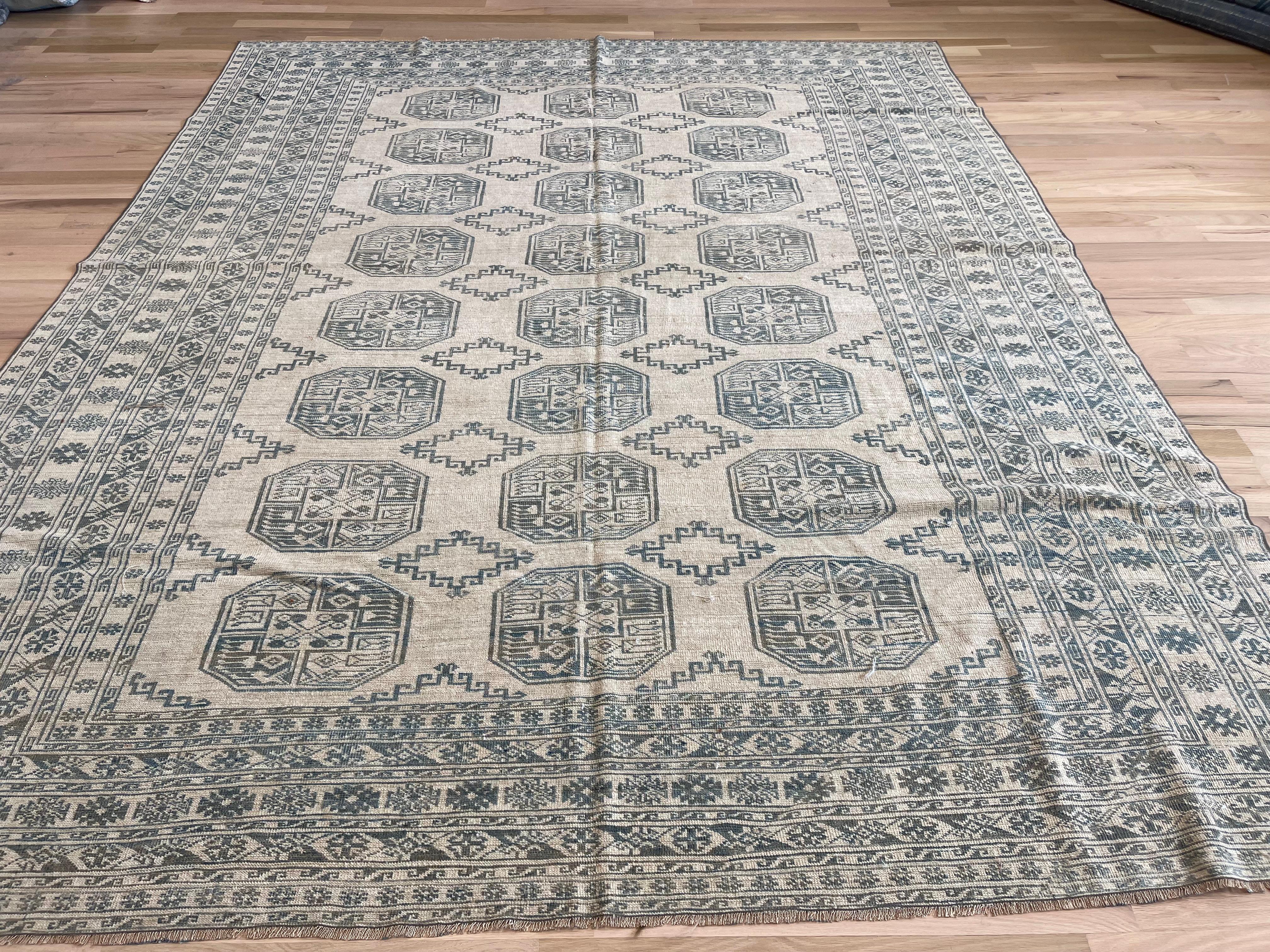 I colori beige e blu dominano questo tappeto. La combinazione di forme geometriche e motivi a rombi dà vita a un design interessante e divertente, che fa pensare al design Khotan. Sebbene il tappeto abbia un campo beige semplice con alcune forme