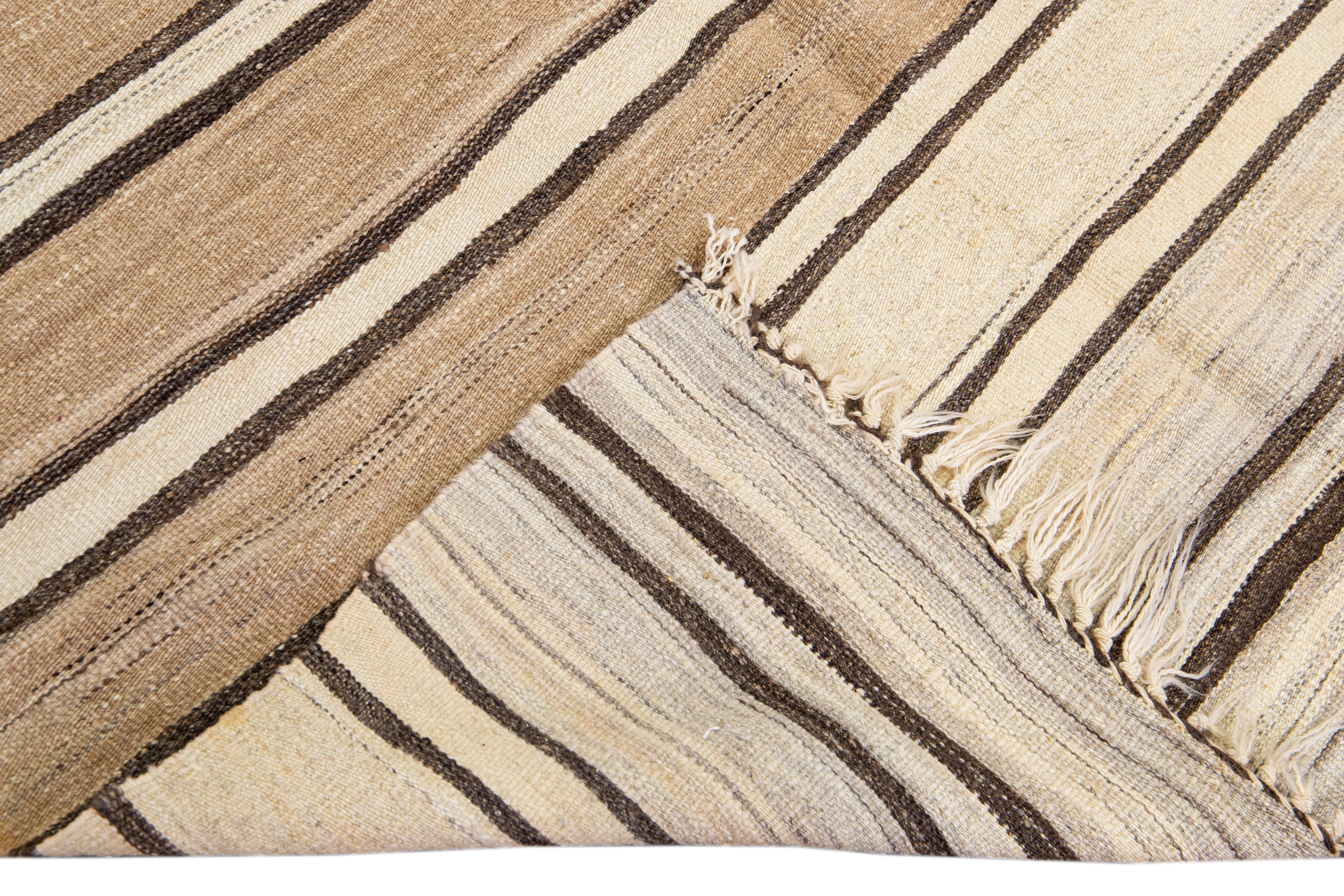 Beautiful kilim handmade wool rug with a beige field. This Vintage flatweave rug has brown Striped accents features a gorgeous all-over design with beige fringes.

This rug measures: 4'9