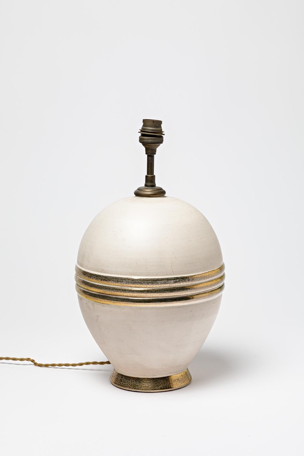 Lampe de table en céramique beige et or / argentée.
Vers 1920-1930.
H : 9.8' x 7.1' pouces (céramique uniquement).
Vendu avec un système électrique européen.