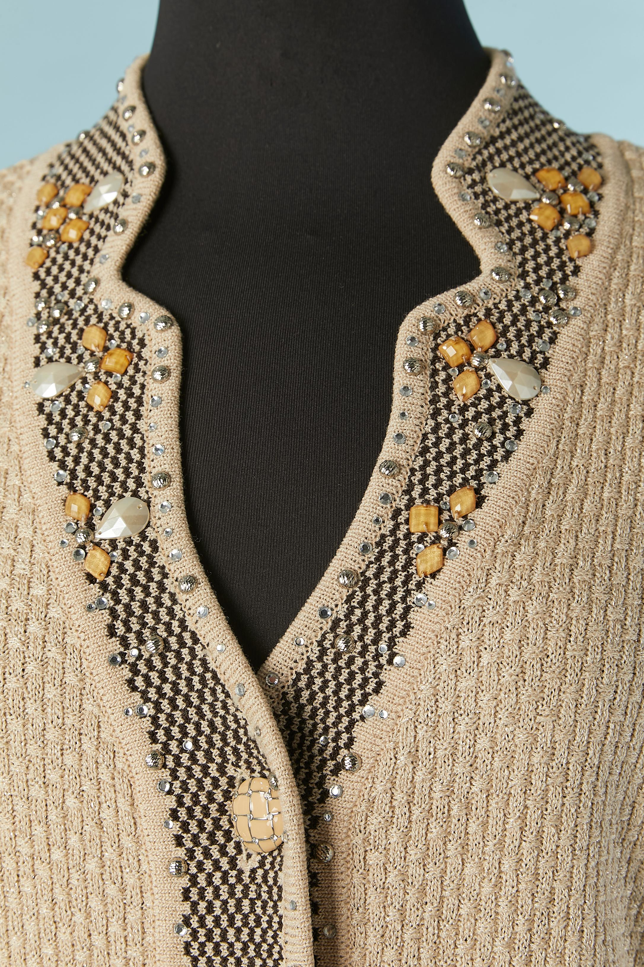 Beigefarbene Jacquard-Strickjacke mit Strassstein- und Perlenverzierung. 
Das Etikett mit der Stoffzusammensetzung wurde abgeschnitten, aber das Gestrick ist wahrscheinlich eine Mischung aus Viskose und Polyester. Auf beiden Seiten geteilt. 
GRÖSSE