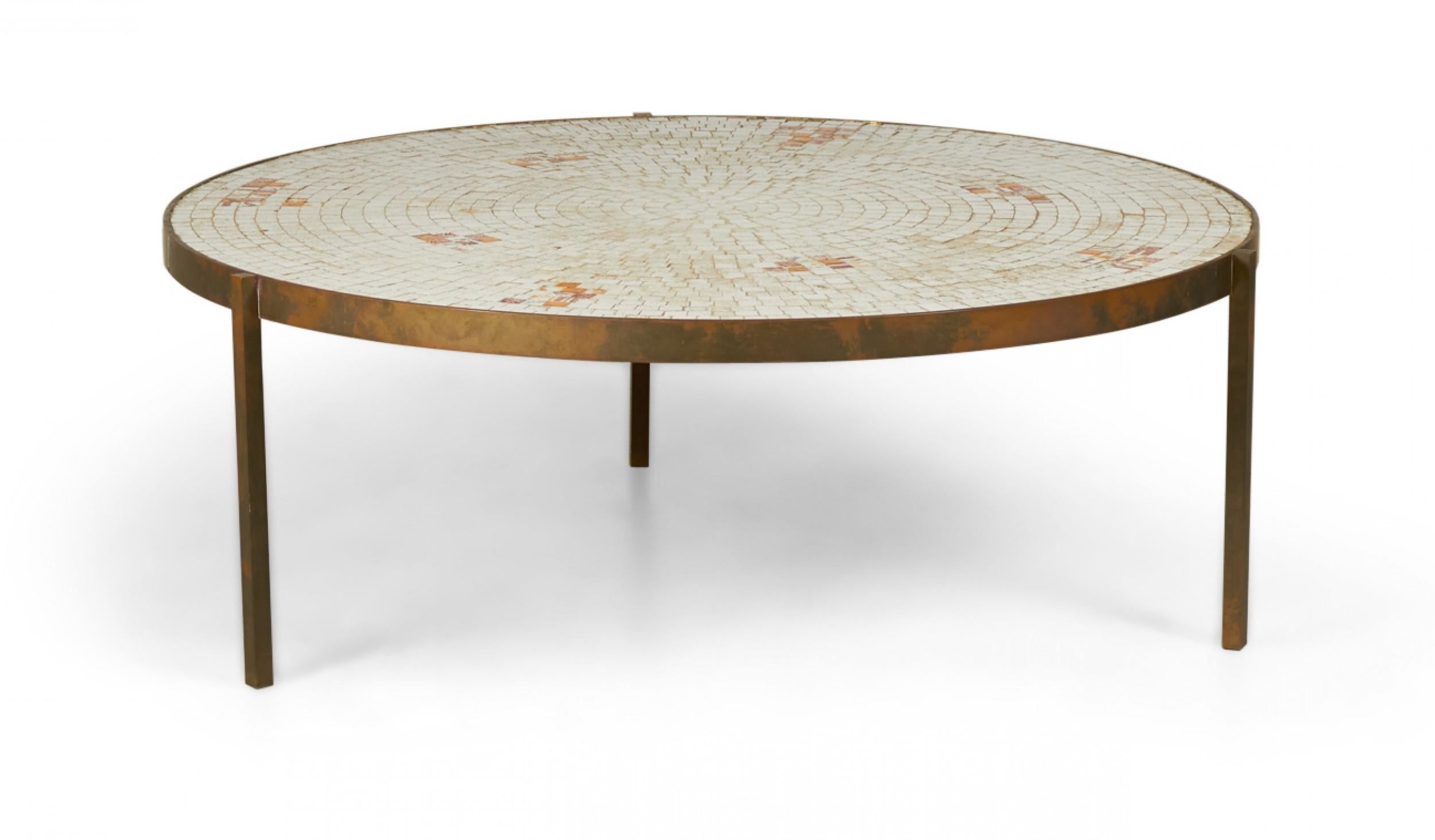 American mid-century circular coffee / cocktail table with a beige and orange mosaic tile top supported by a brass frame with three legs.