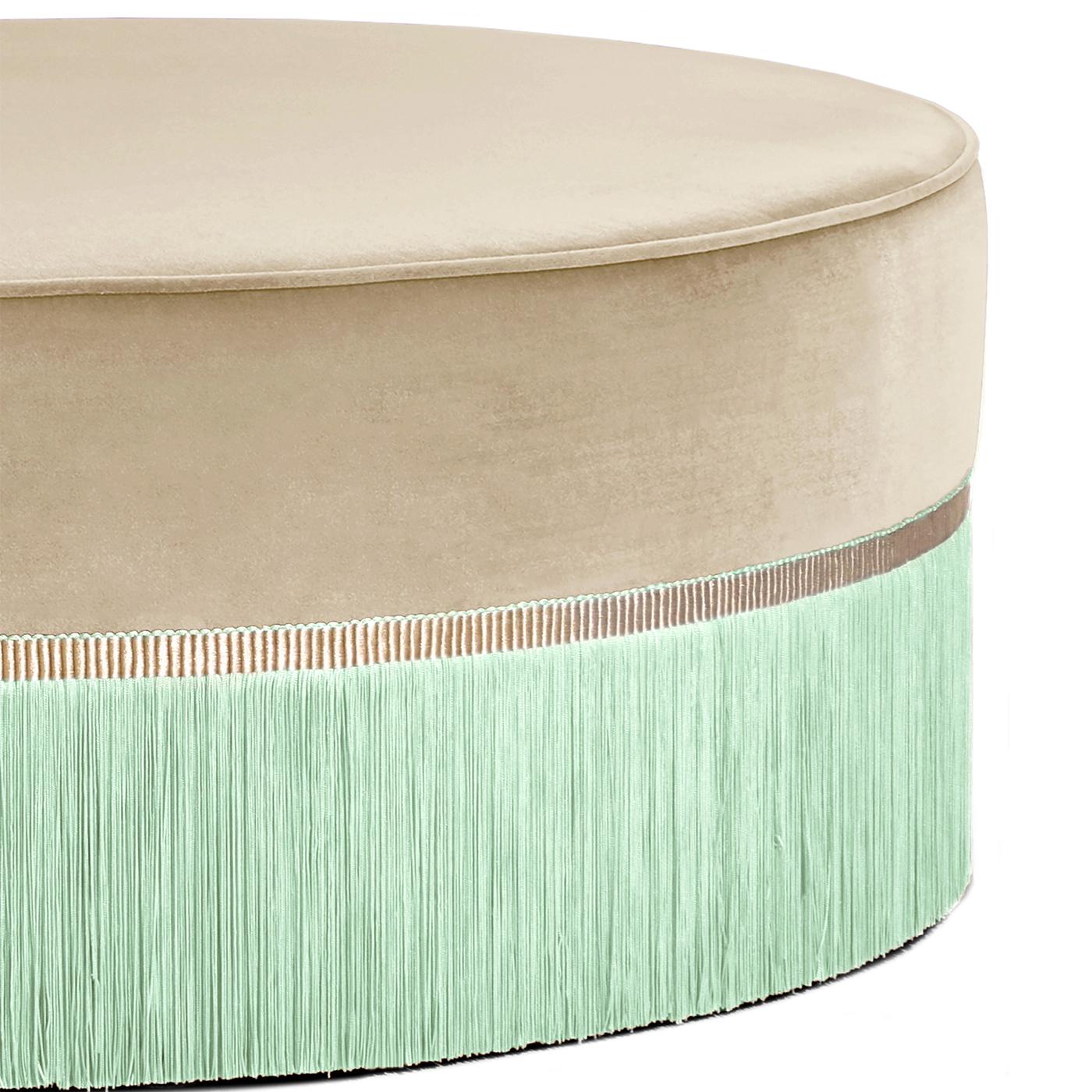 Subtle colors make a strong statement in this pouf from the Couture Geometric Collection. Designed to be used as a coffee table or seat, the pouf is crafted on a beechwood base, upholstered in velvet 100% trevira and completed with viscose fringe