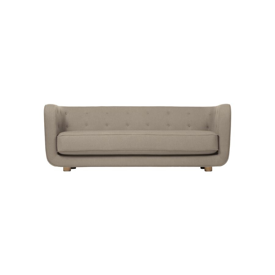 Beige and smoked oak Raf Simons Vidar 3 Vilhelm sofa by Lassen
Dimensions: W 217 x D 88 x H 80 cm 
Materials: Textile, oak.

Vilhelm is a beautiful padded three-seater sofa designed by Flemming Lassen in 1935. A sofa must be able to function in