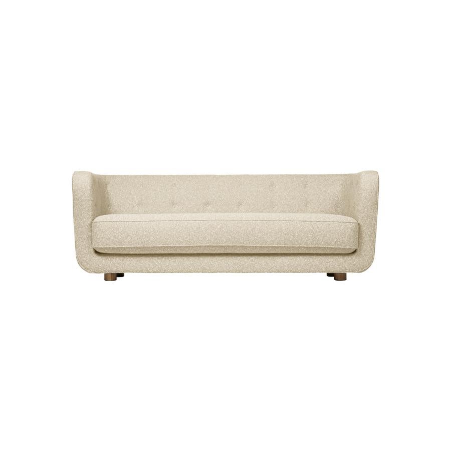 Beige and smoked Oak Sahco Zero Vilhelm sofa by Lassen
Dimensions: W 217 x D 88 x H 80 cm 
Materials: Textile, Oak.

Vilhelm is a beautiful padded 3-seater sofa designed by Flemming Lassen in 1935. A sofa must be able to function in several