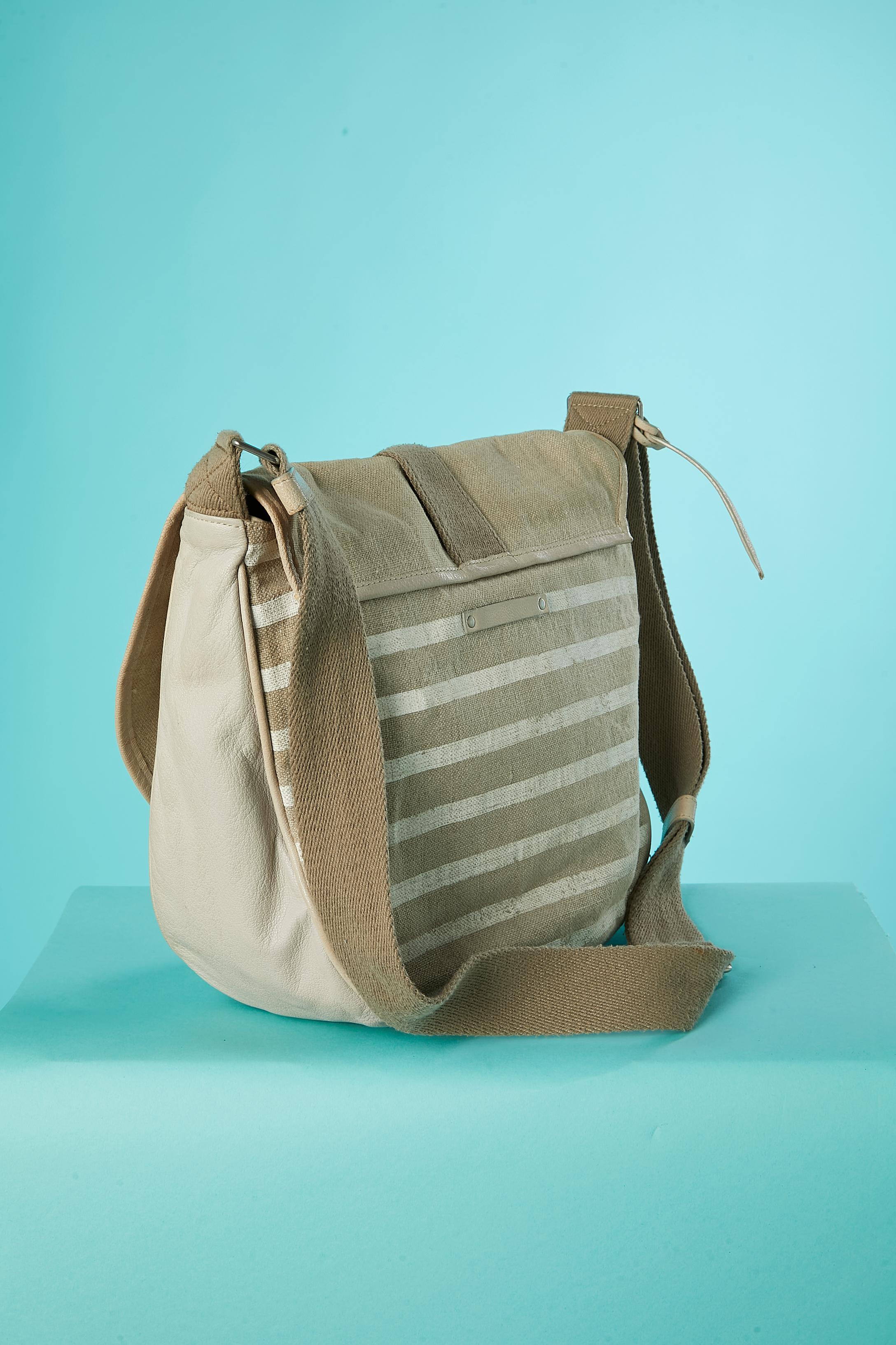 Beige and striped cotton and leather cross-body bag. Branded nylon lining. One large inside pocket with zip and 2 flat pockets. Pencil stain on the lining and one stain on the shoulder strap. 
SIZE: 30 cm X 30 cm X 12 cm 
Adjustable shoulder strap: