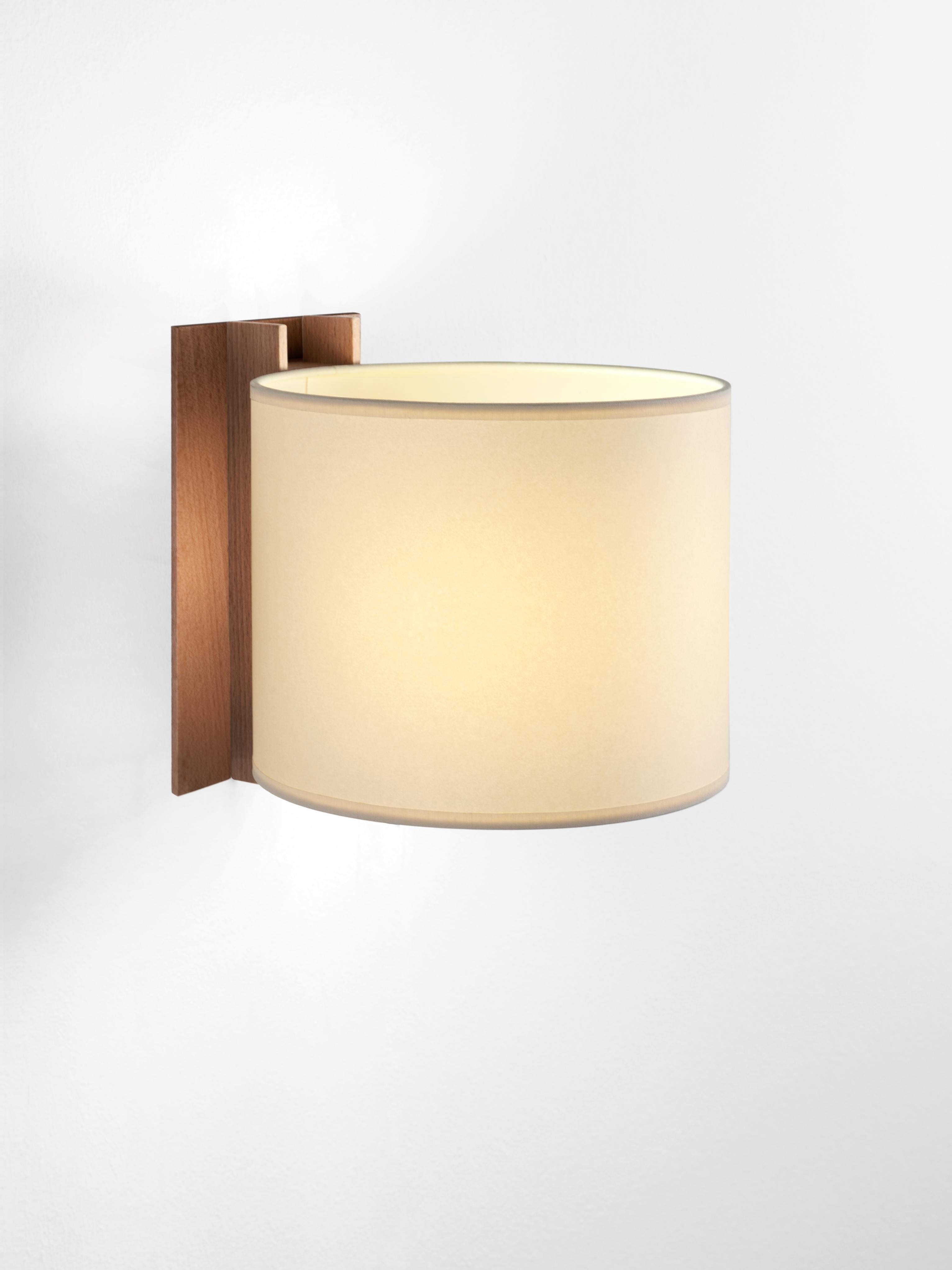 Beige and walnut TMM Corto wall lamp by Miguel Milá.
Dimensions: D 20 x W 23 x H 20 cm.
Materials: Metal, walnut wood, parchment lampshade.
Direct wall.
Available in beech or walnut and in white or beige lampshade.
Available with plug or direct