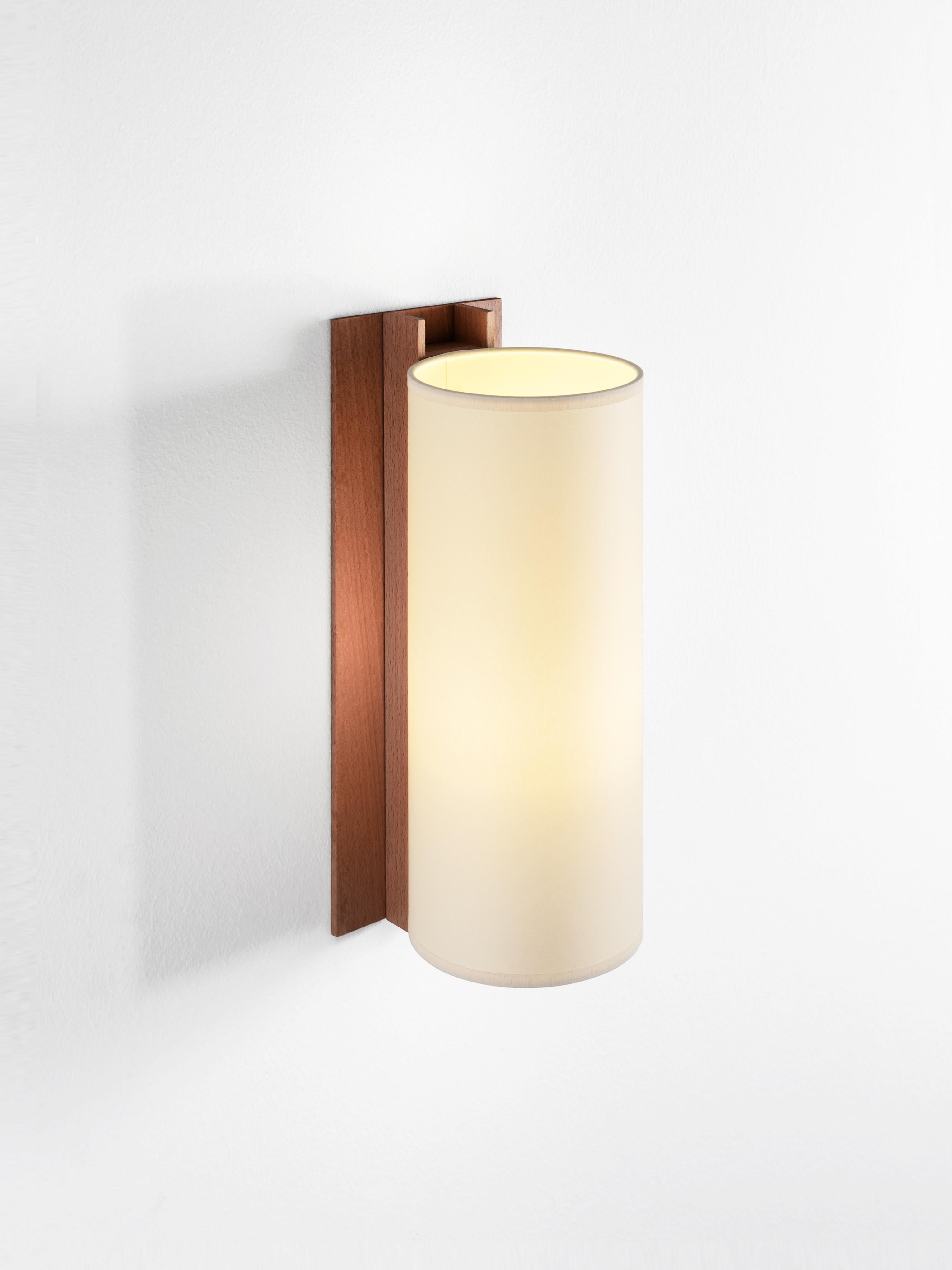 Beige and Walnut TMM Largo wall lamp by Miguel Milá.
Dimensions: D 12 x W 15 x H 34 cm.
Materials: Metal, walnut wood, parchment lampshade.
Available in beech or walnut and in white or beige lampshade.

The long and short wall lamps belonging