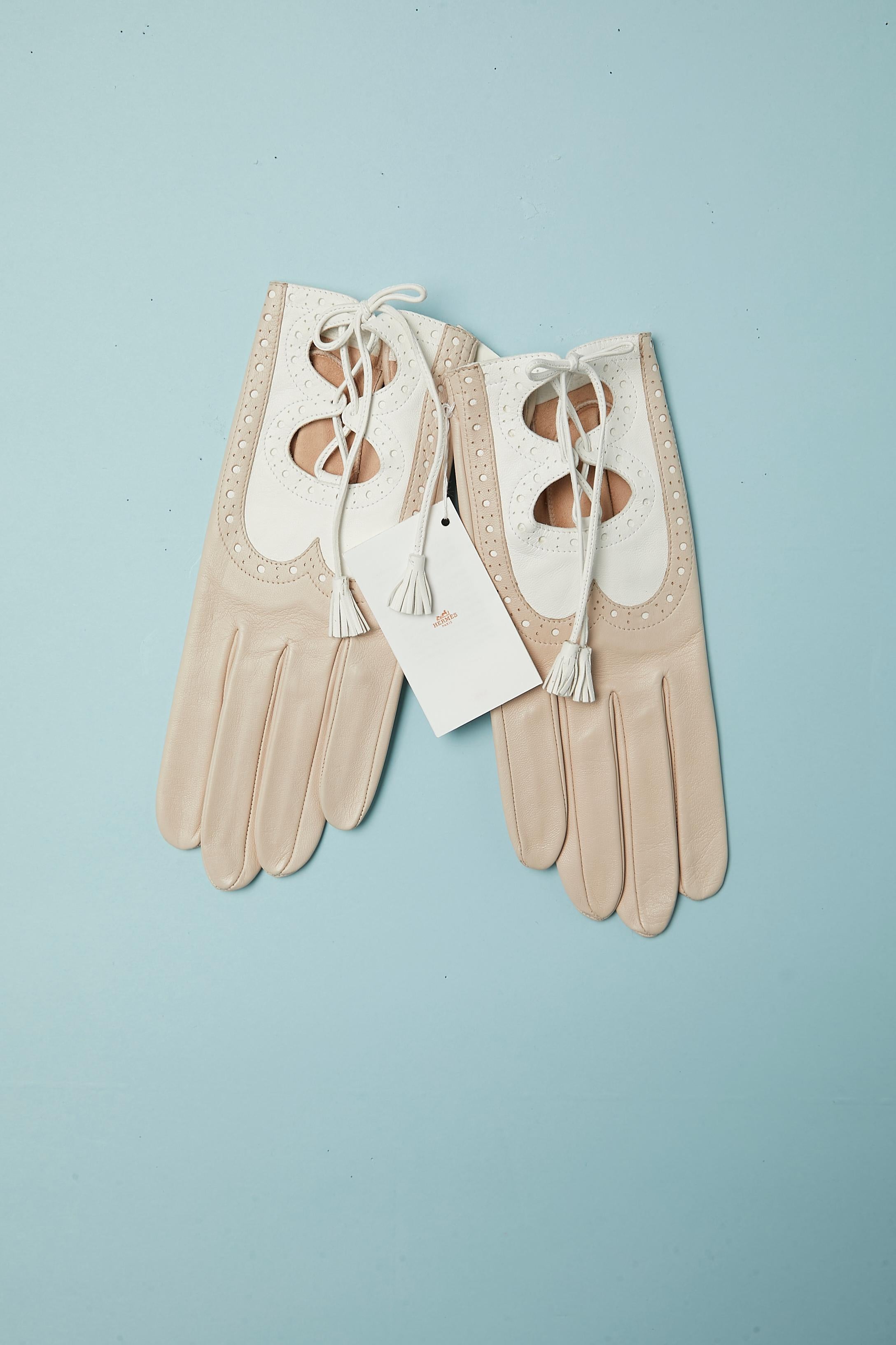 Beige and white leather gloves with cut-work, leather laces and white leather pompom. Snap cover with leather inside the hand.
SIZE 7 1/2
New with tag