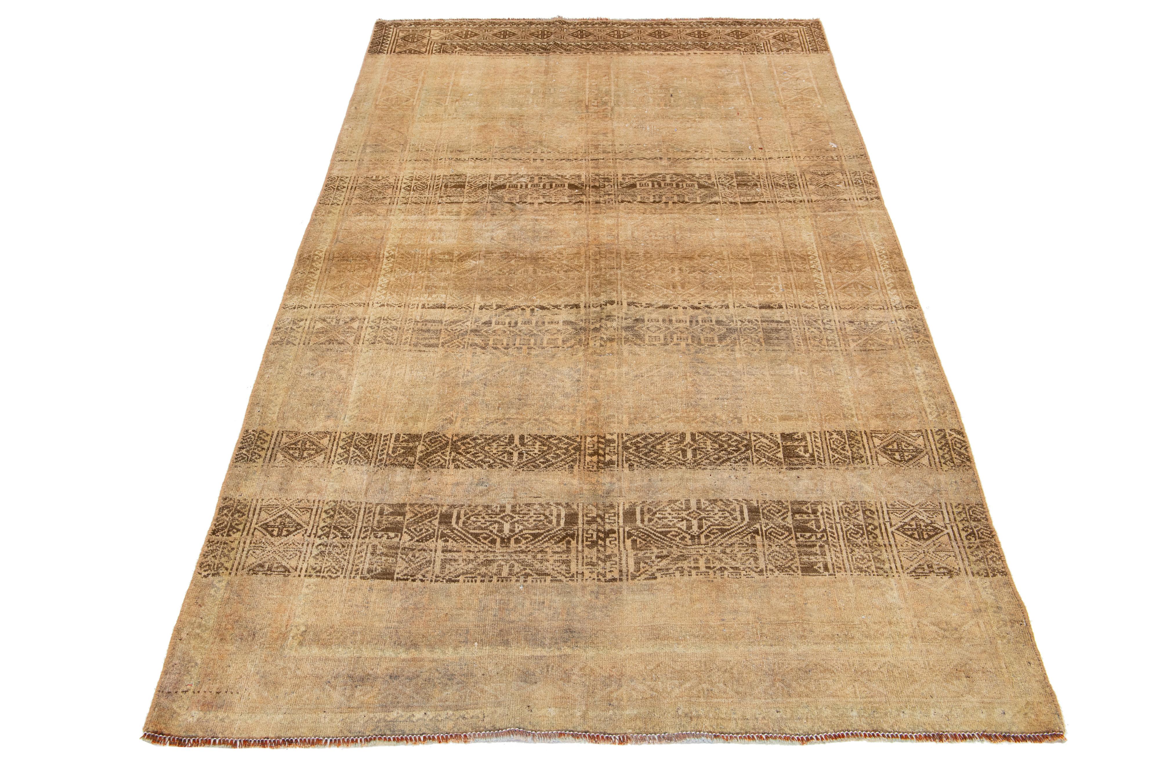 This antique Hamadan rug is hand-knotted from premium wool, boasting a beige field complemented by a captivating, all-over pattern design with brown accents.

This rug measures 4'2