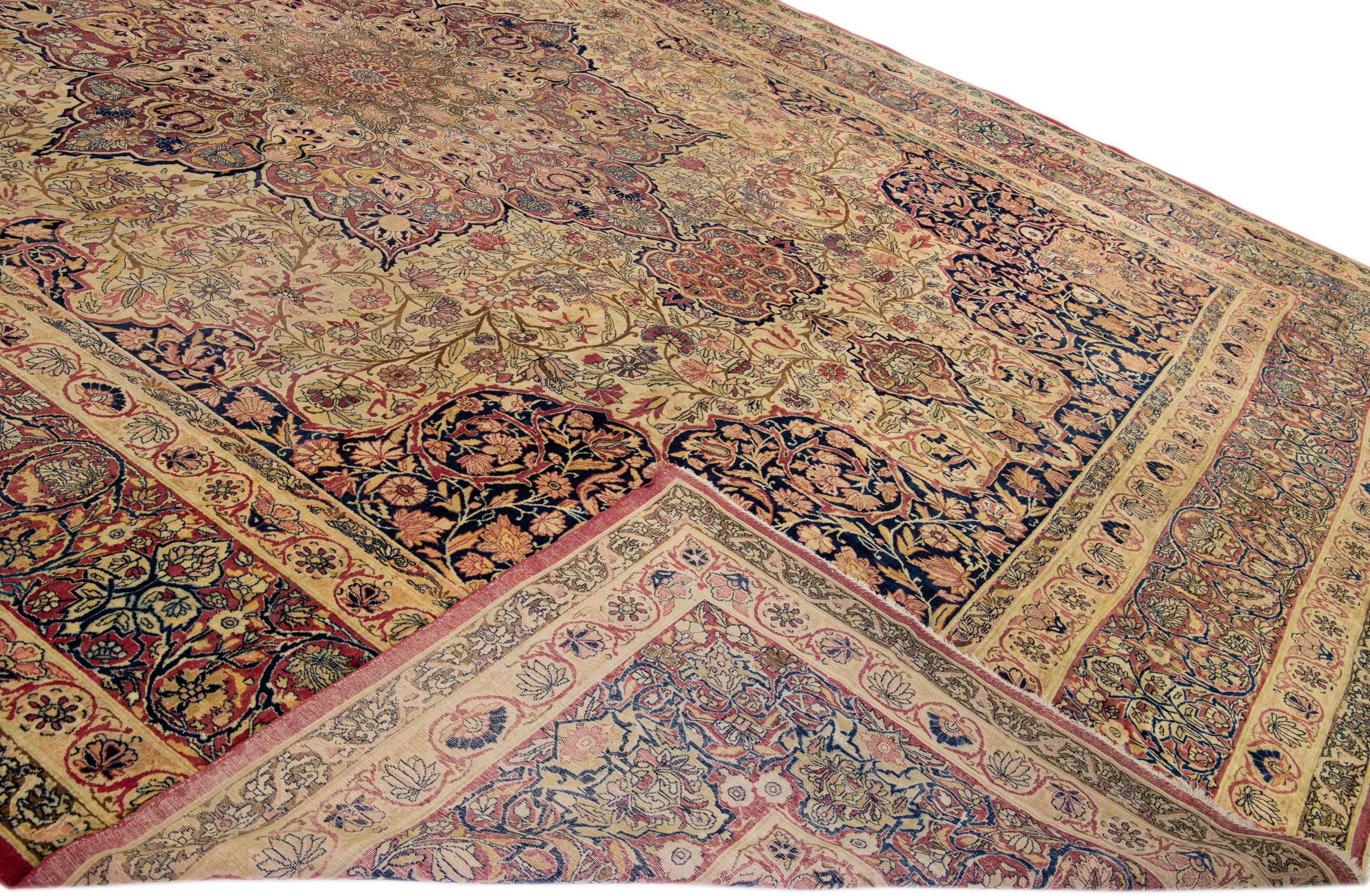 Beautiful antique Kerman hand-knotted wool rug with a beige and red field. This Persian rug has multicolor accents in a gorgeous all-over rosette pattern design.

This rug measures: 14' x 19'9