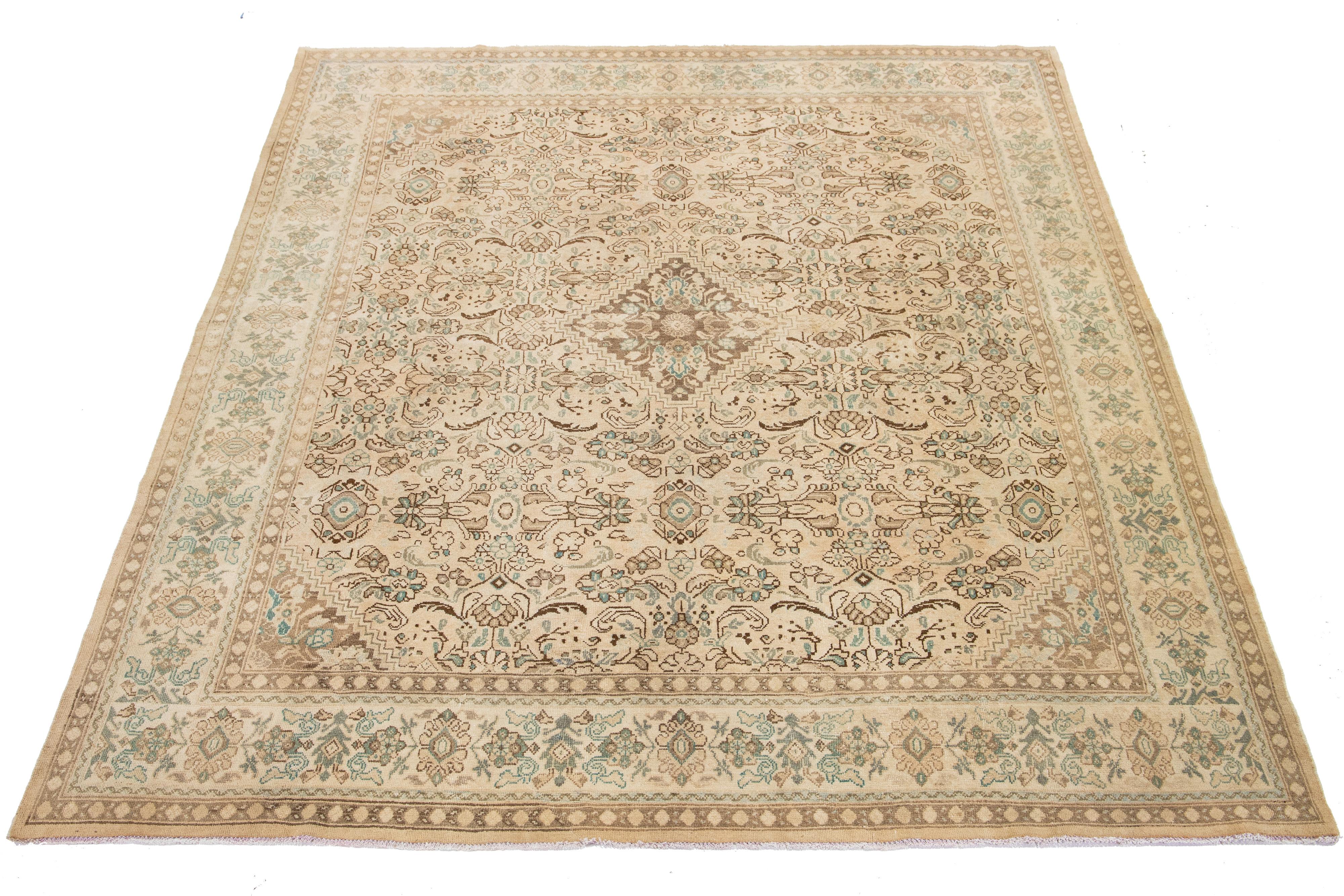 This antique Persian Mahal wool rug has a beige background and blue and brown floral designs.

This rug measures 9'5