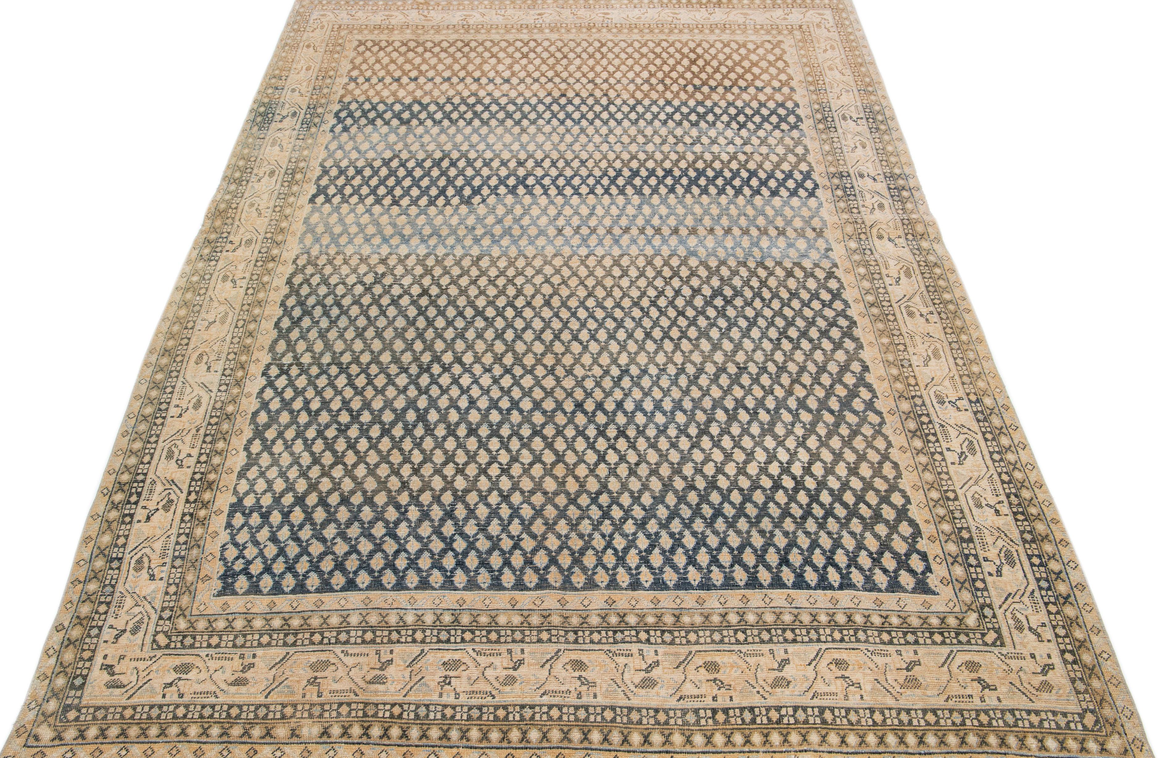 Beautiful antique Malayer hand-knotted wool rug with a beige color field. This Persian piece has blue accents in an all-over geometric pattern. 

This rug measures: 6'11