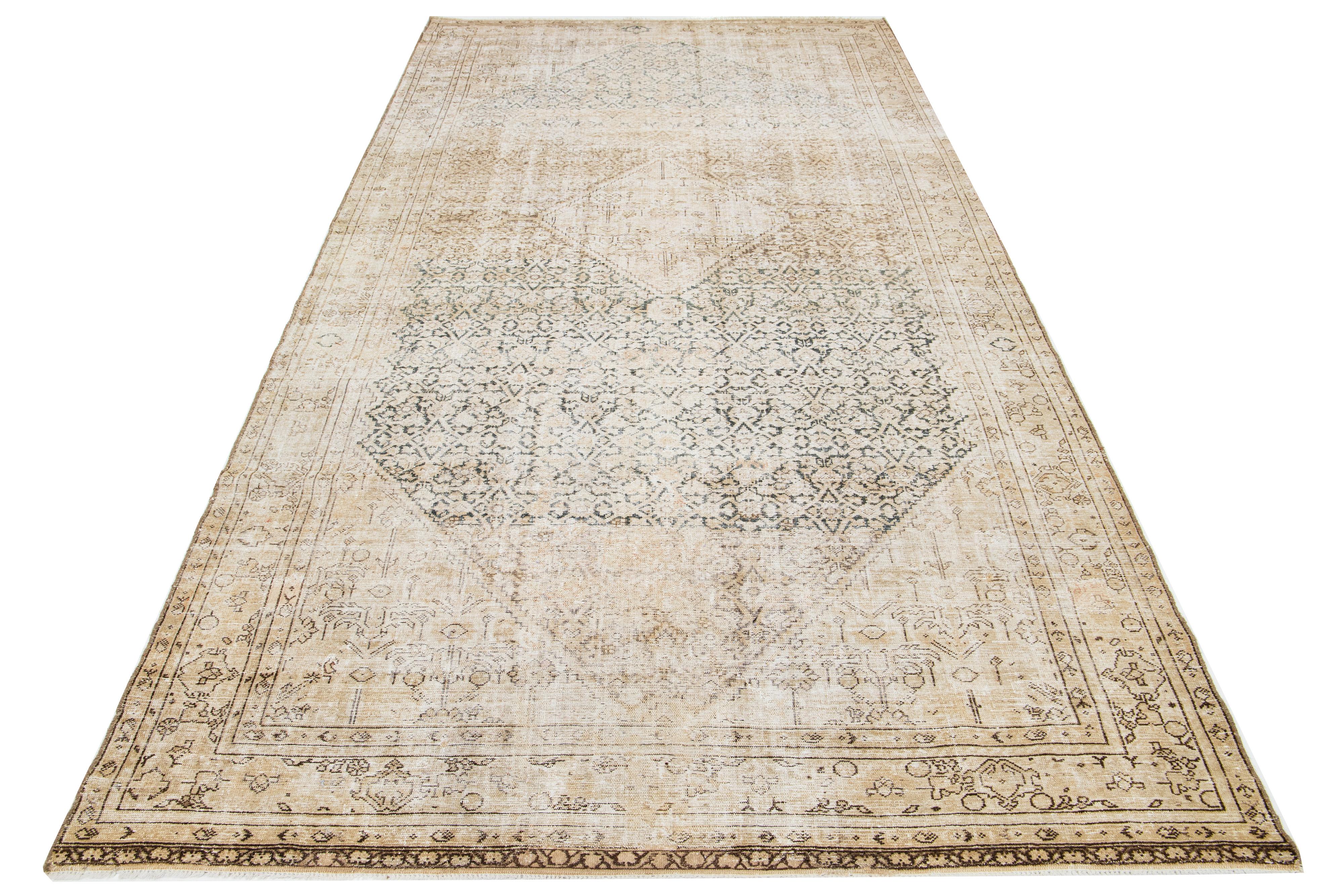 This is a handmade Persian Malayer wool rug from the 20th century. The rug has a beige background with woven brown and blue accents throughout its design.

This rug measures 6'4
