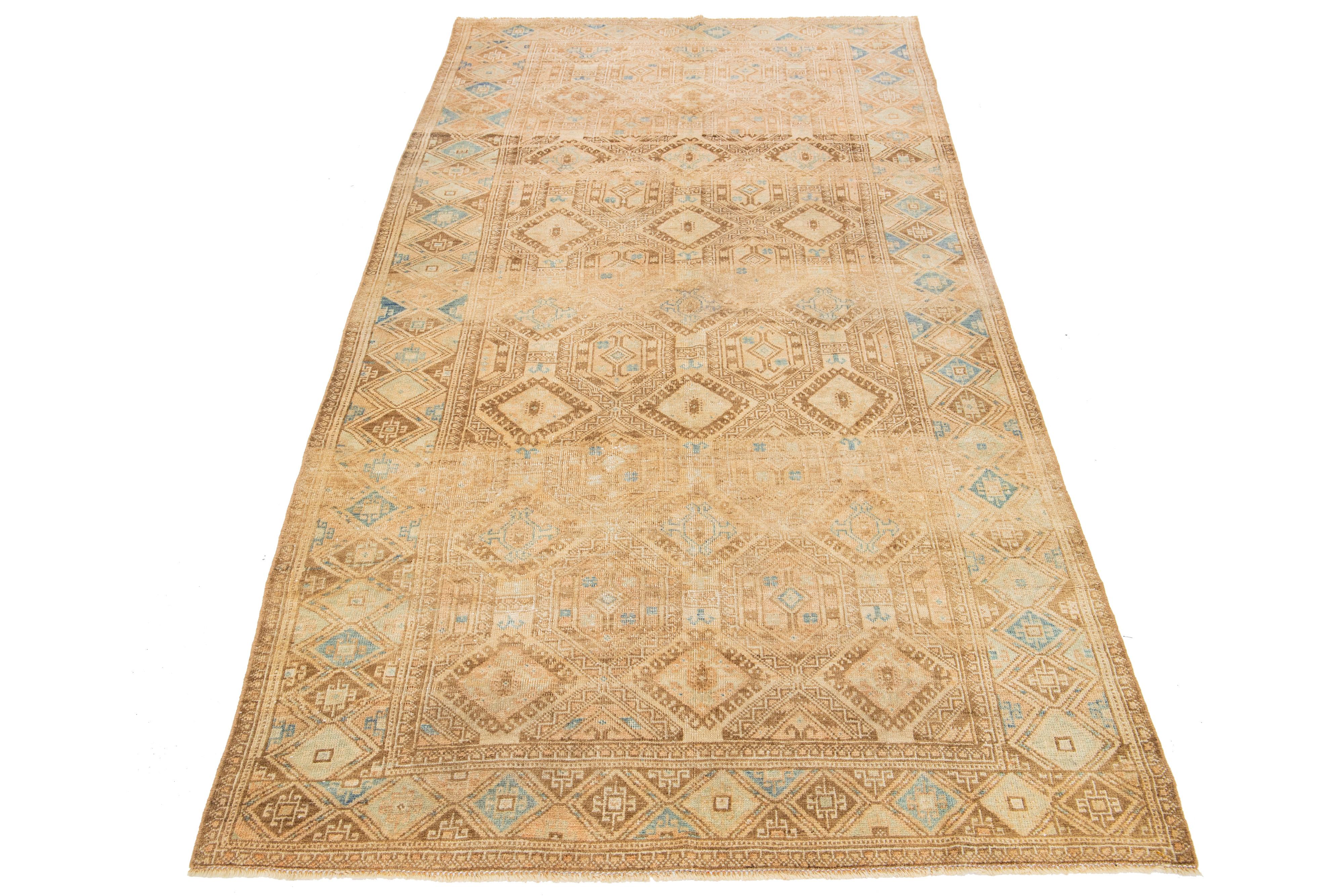 Beautiful vintage Persian hand-knotted wool rug with a beige color field. This piece has a designed frame with blue and brown accents in a gorgeous all-over geometric pattern.

This rug measures 4'10