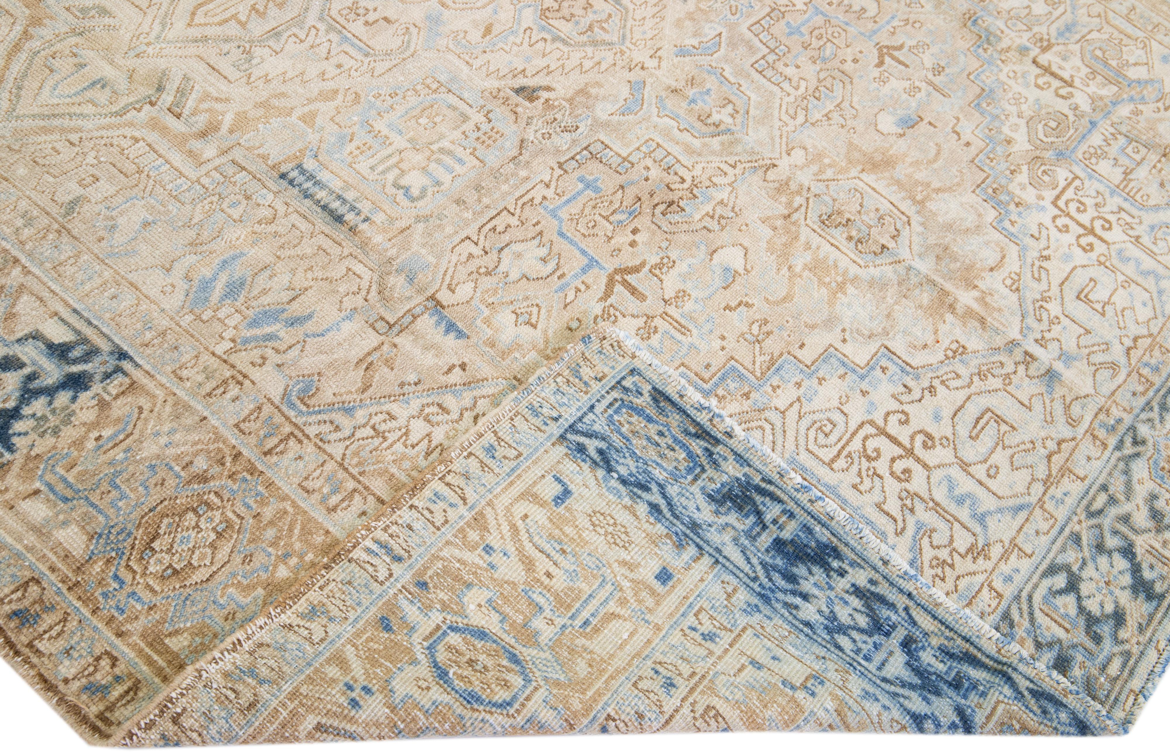 Beautiful antique Heriz hand-knotted wool rug with a beige color field. This Persian rug has blue accents in a gorgeous all-over geometric medallion design.

This rug measures: 8'1