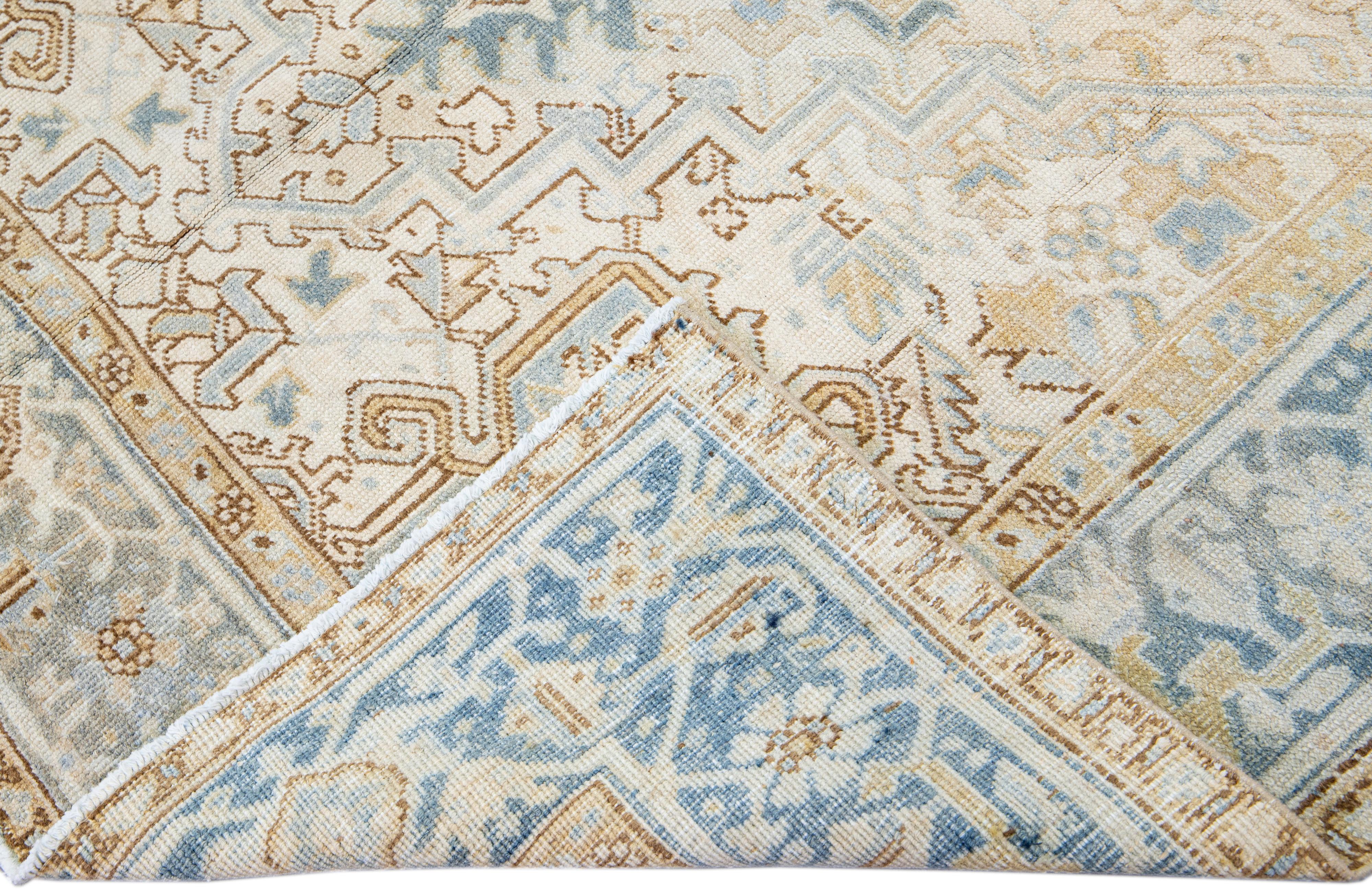 Beautiful antique Heriz hand-knotted wool rug with a beige field. This Persian rug has a blue frame and accents in a gorgeous all-over layout geometric medallion floral motif.

This rug measures: 6'9