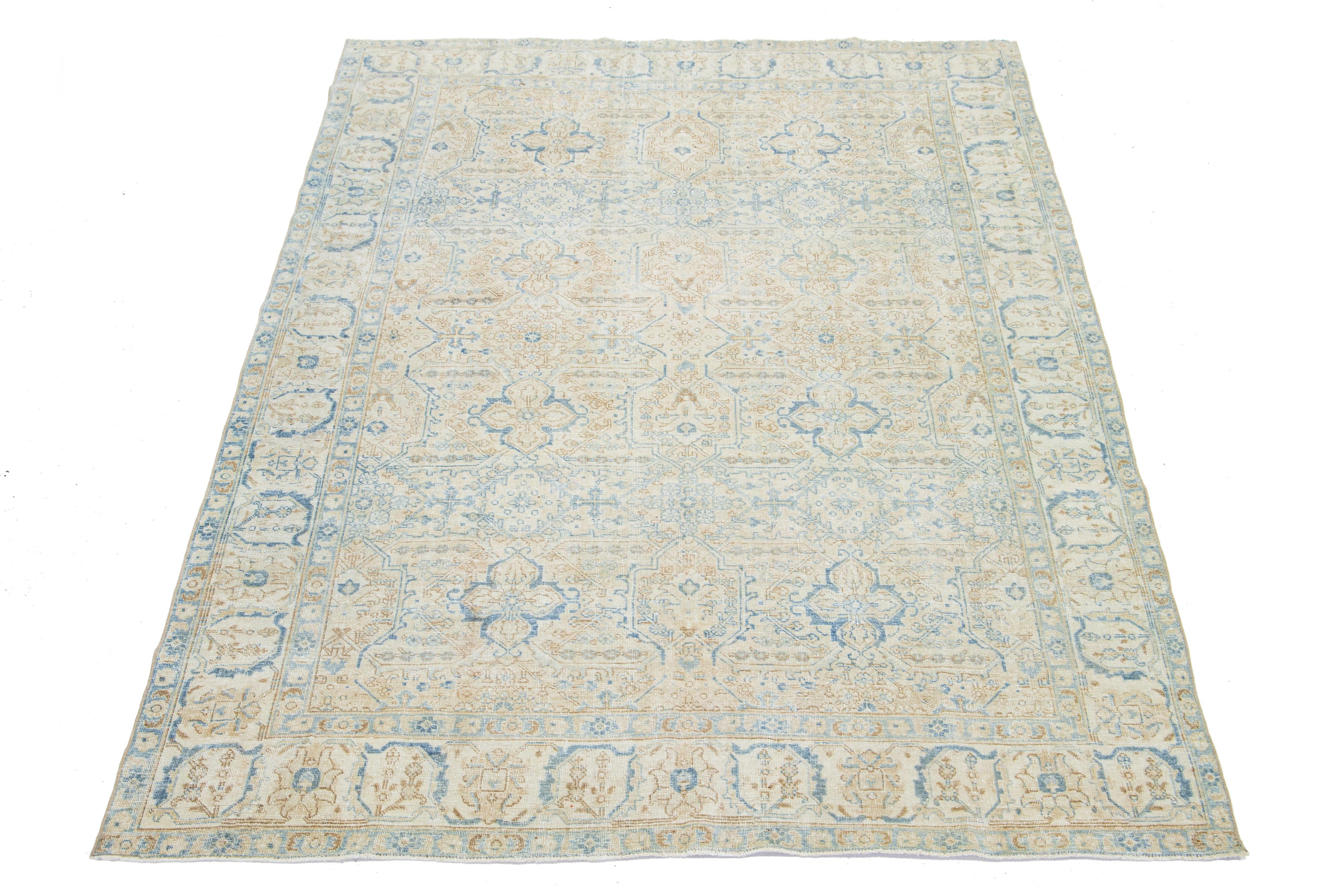 This antique Persian Heriz rug is crafted with hand-knotted wool. The beige-colored field features a captivating allover pattern embellished with shades of blue and brown.

This rug measures 6'6