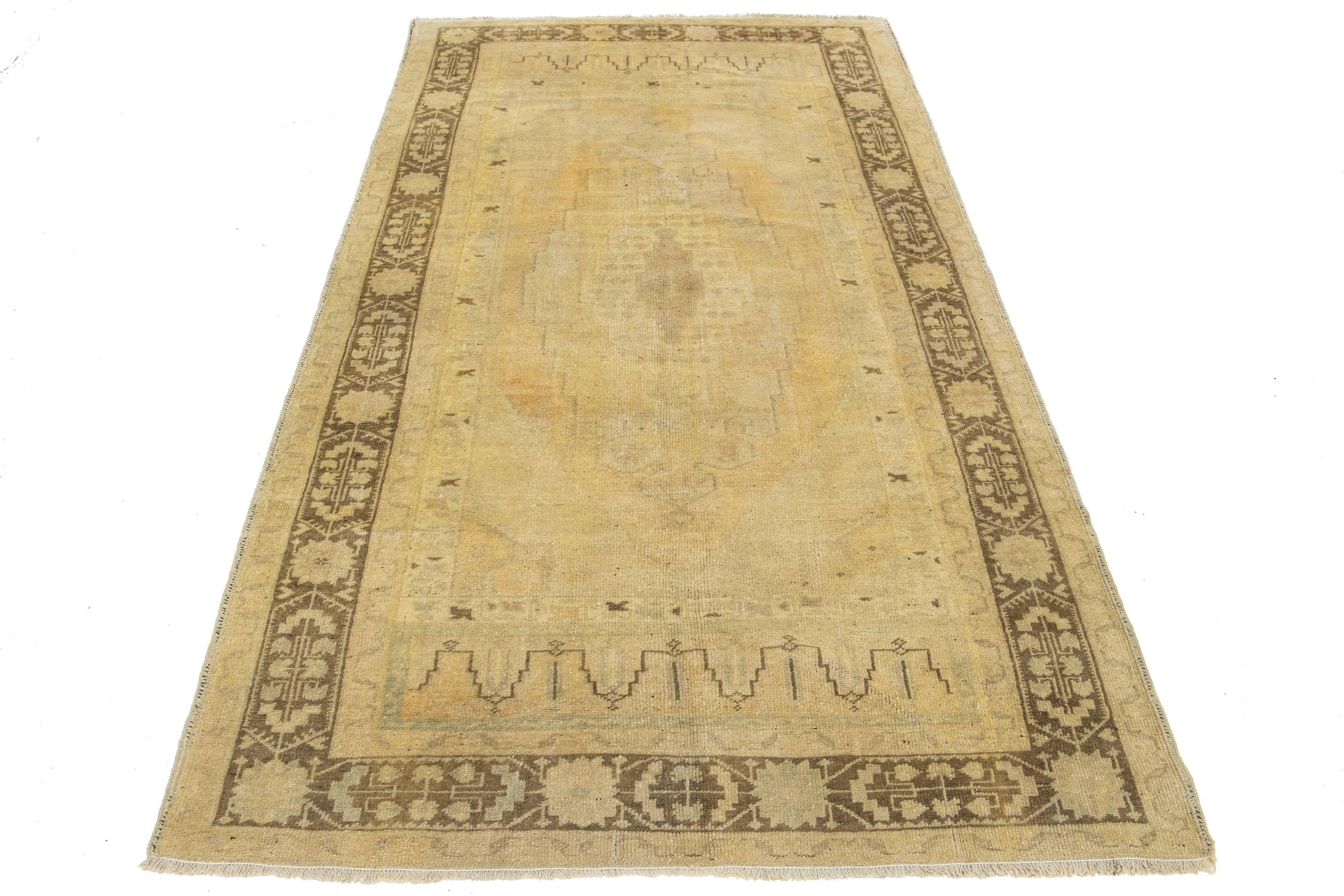 Beautiful Antique Turkish khotan hand-knotted wool rug with a beige field. This Khotan has brown and light orange accents in a gorgeous all-over medallion motif.

This runner measures 4'6