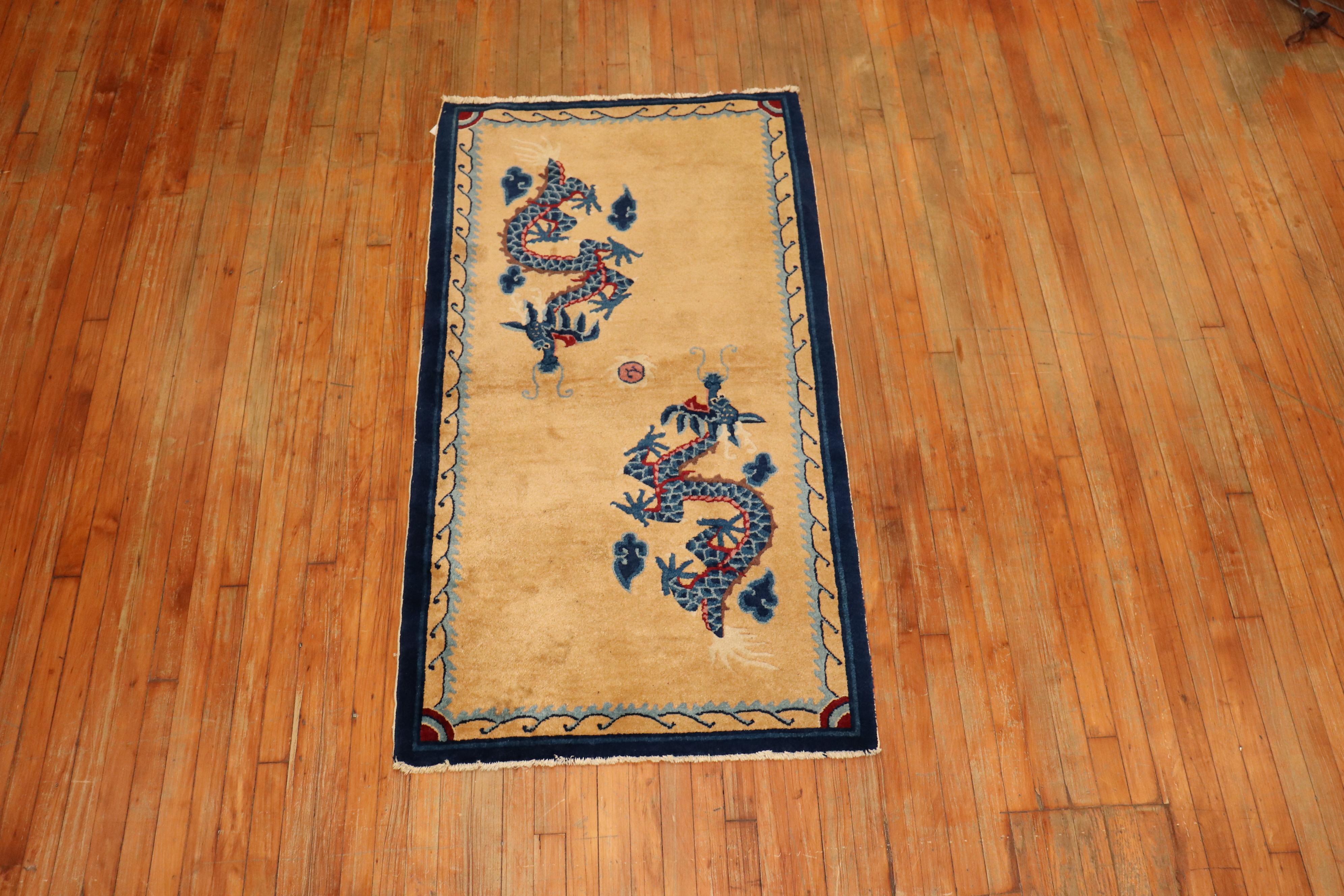 A vintage Tibetan rug from the mid-20th century with 2 blue dragons floating on a beige ground.

Measures: 3' x 5'8