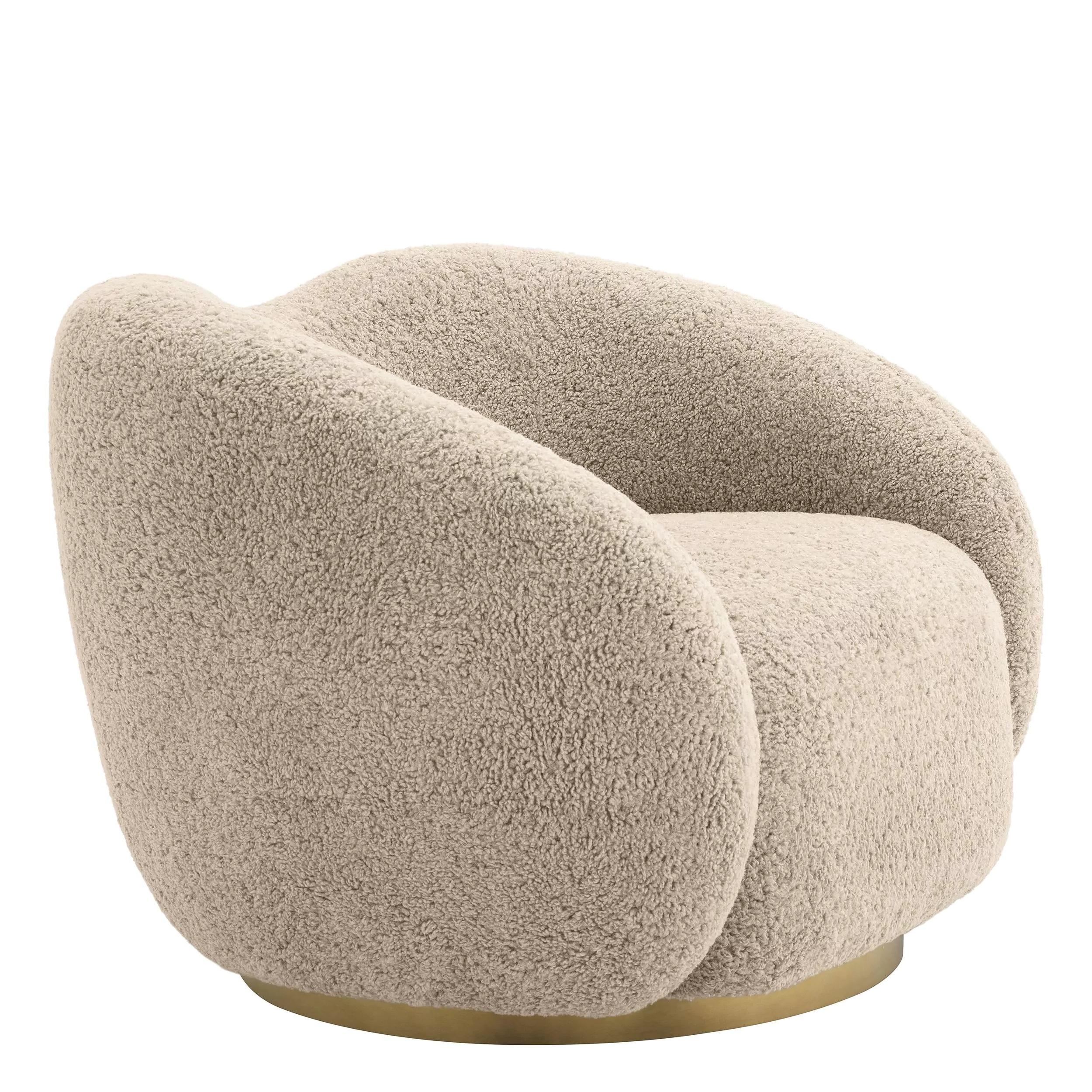 Fauteuil pivotant accueillant et courbé en tissu bouclé beige doux avec base aux finitions en laiton.