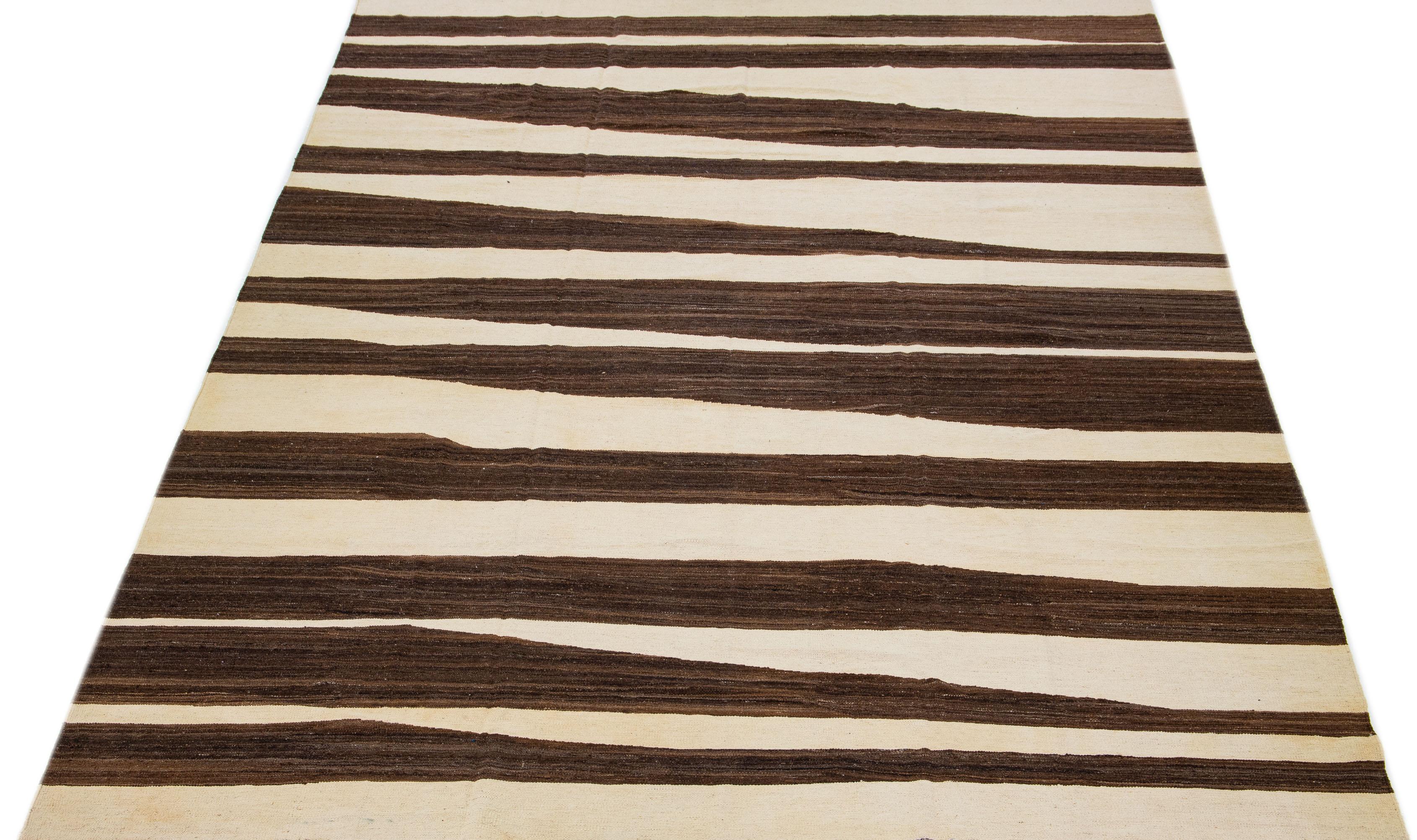 Le tapis Rug & Kilim, méticuleusement confectionné, arbore un design contemporain, avec un champ beige dominant accentué par des motifs géométriques abstraits dans les tons de brun.

Ce tapis mesure 10' x 14'.

