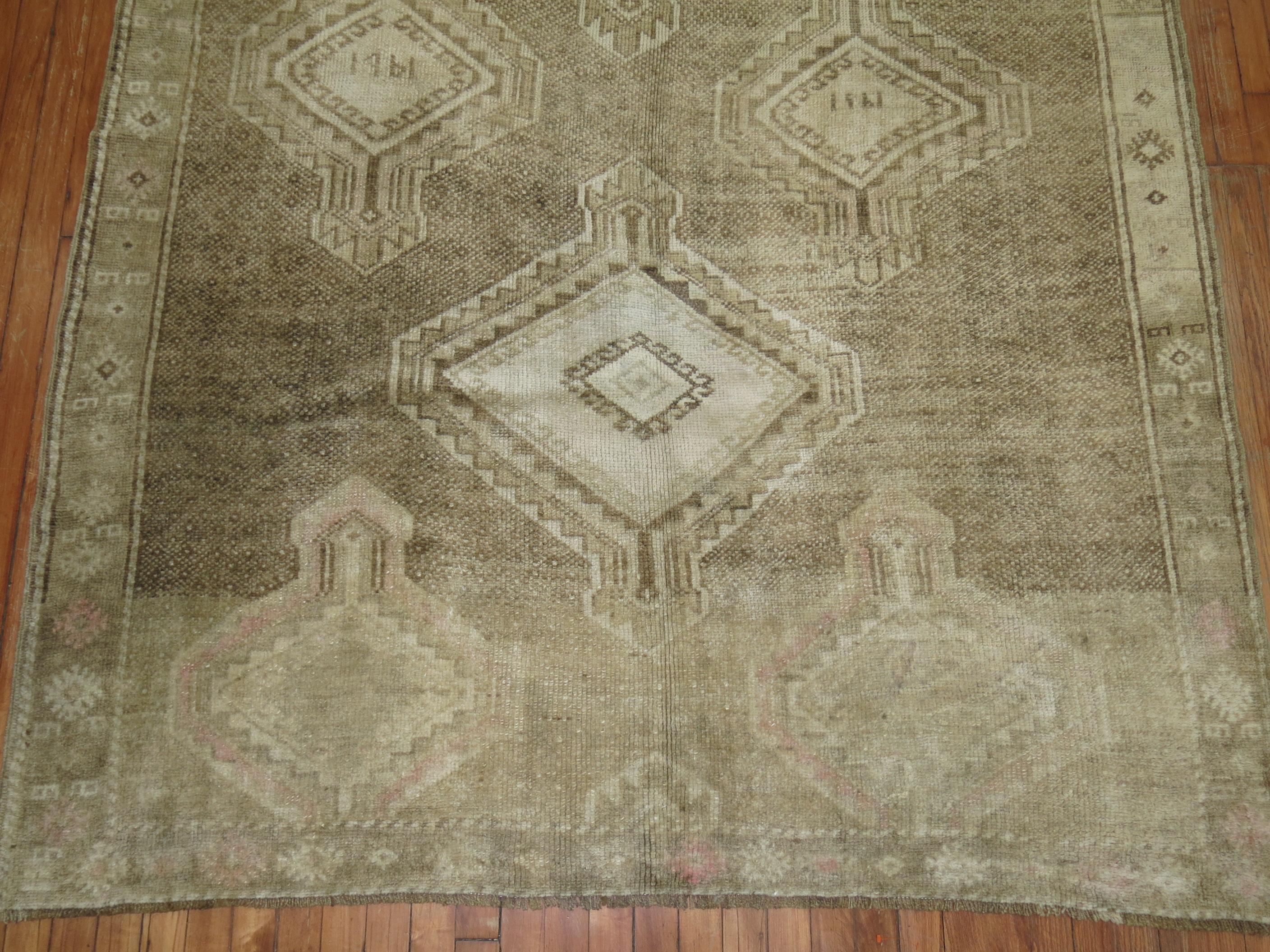 A Turkish Kars runner with a large scale geometric tribal medallion design throughout. There is some faded pink tones on 1 end of the rug, predominantly in brown and beige tones.

5'8'' x 11'7''

Kars is a village located in Northeast of Turkey. The