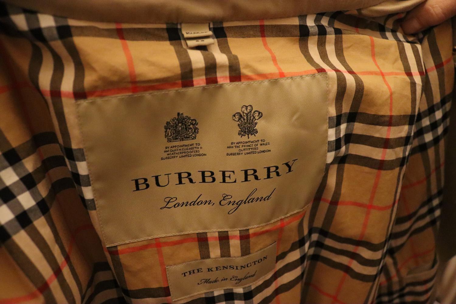 The iconic Burberry trench coat made in England from shower resistant gabardine. Inside is Burberry check cotton used to line coats since the 1920s.The coat has a double breasted button closure, hook and eye collar closure , epaulettes, belt and