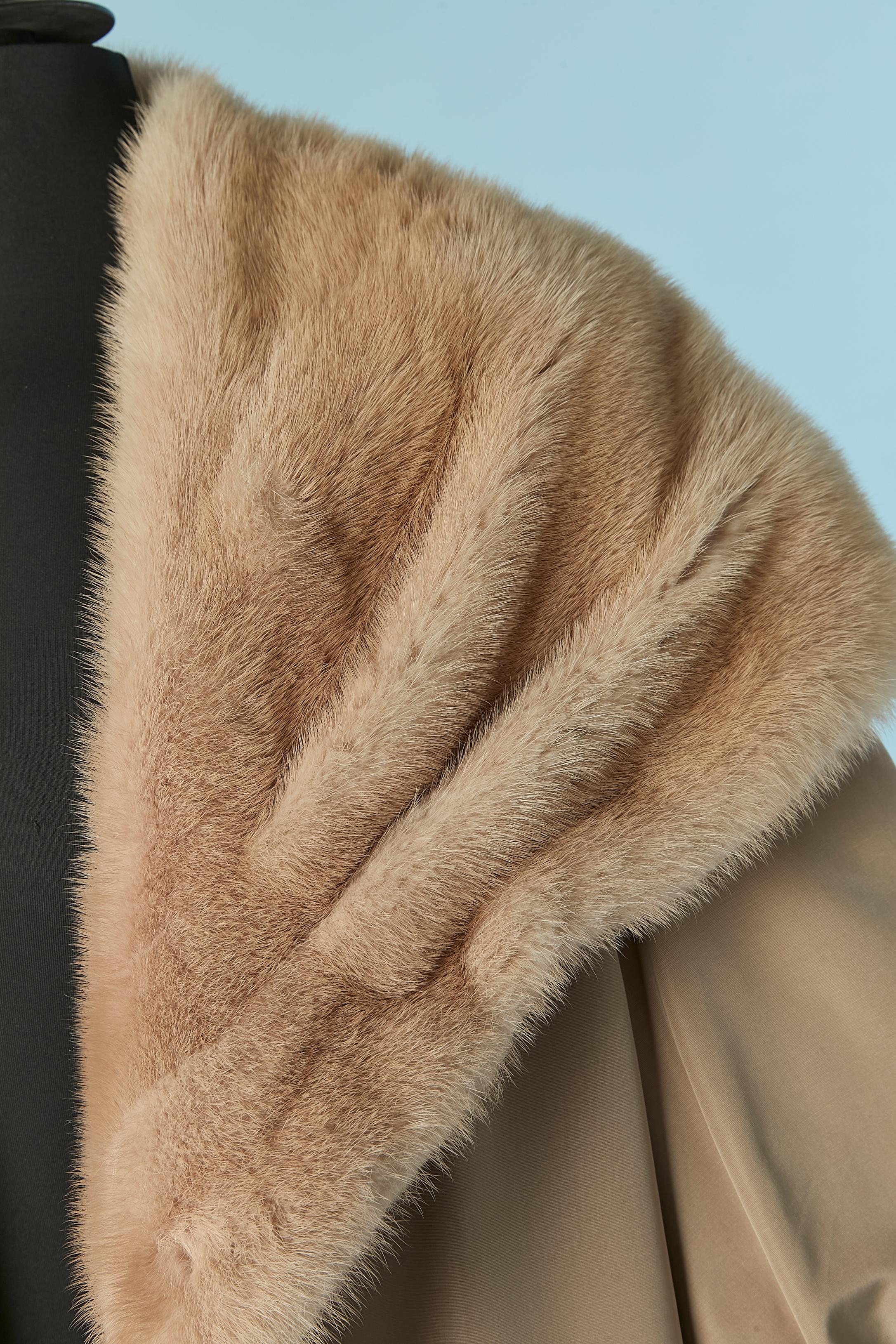 Beige coat with fur lining. There is no fabric tag composition but the shell is probably made of rayon and the inside fur is mink ( collar and cuff) and the fur inside the body is probably rabbit. The fur lining is detachable with button and
