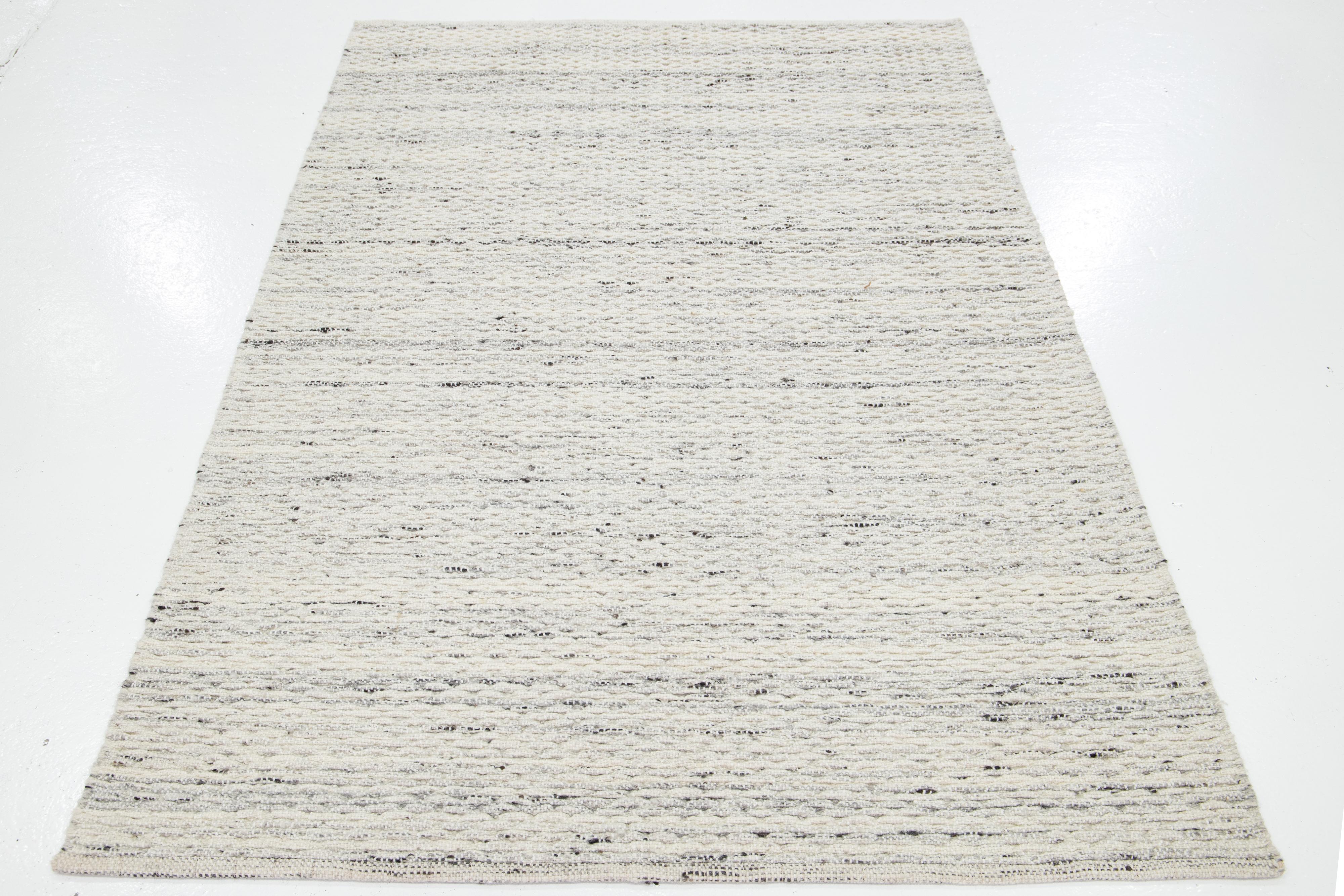 This beautiful Felt hand-woven wool rug is part of our Westport Collection. It has a beige field with gray-charcoal accents throughout the geometric design.

This rug measures 5' x 8'.

Custom colors and sizes are available upon request.

