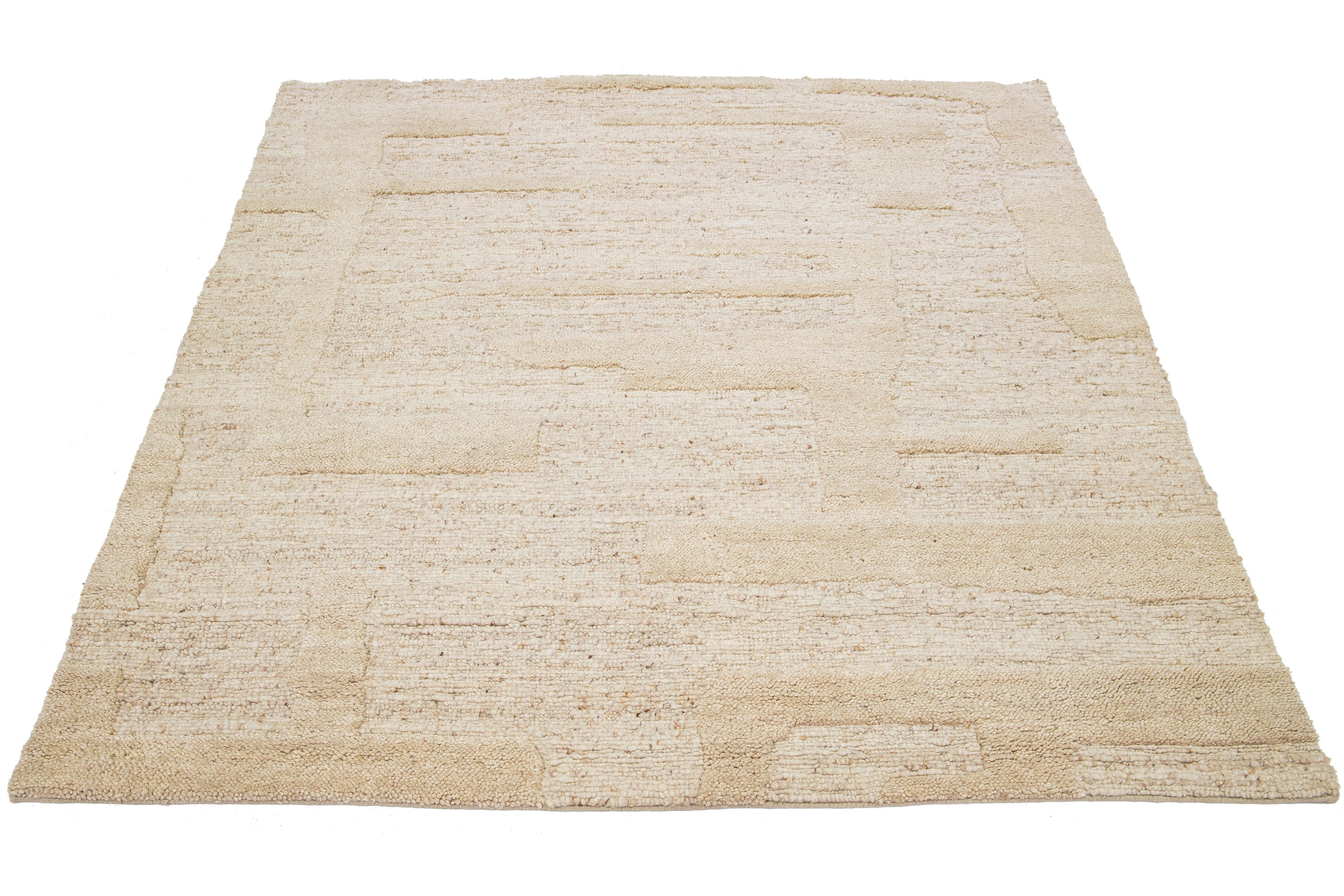 This Moroccan-style wool rug is hand-knotted, boasting a beautiful modern design with a natural beige-tan field. The rug showcases a stunning geometric pattern.

This rug measures 8' x 10'.