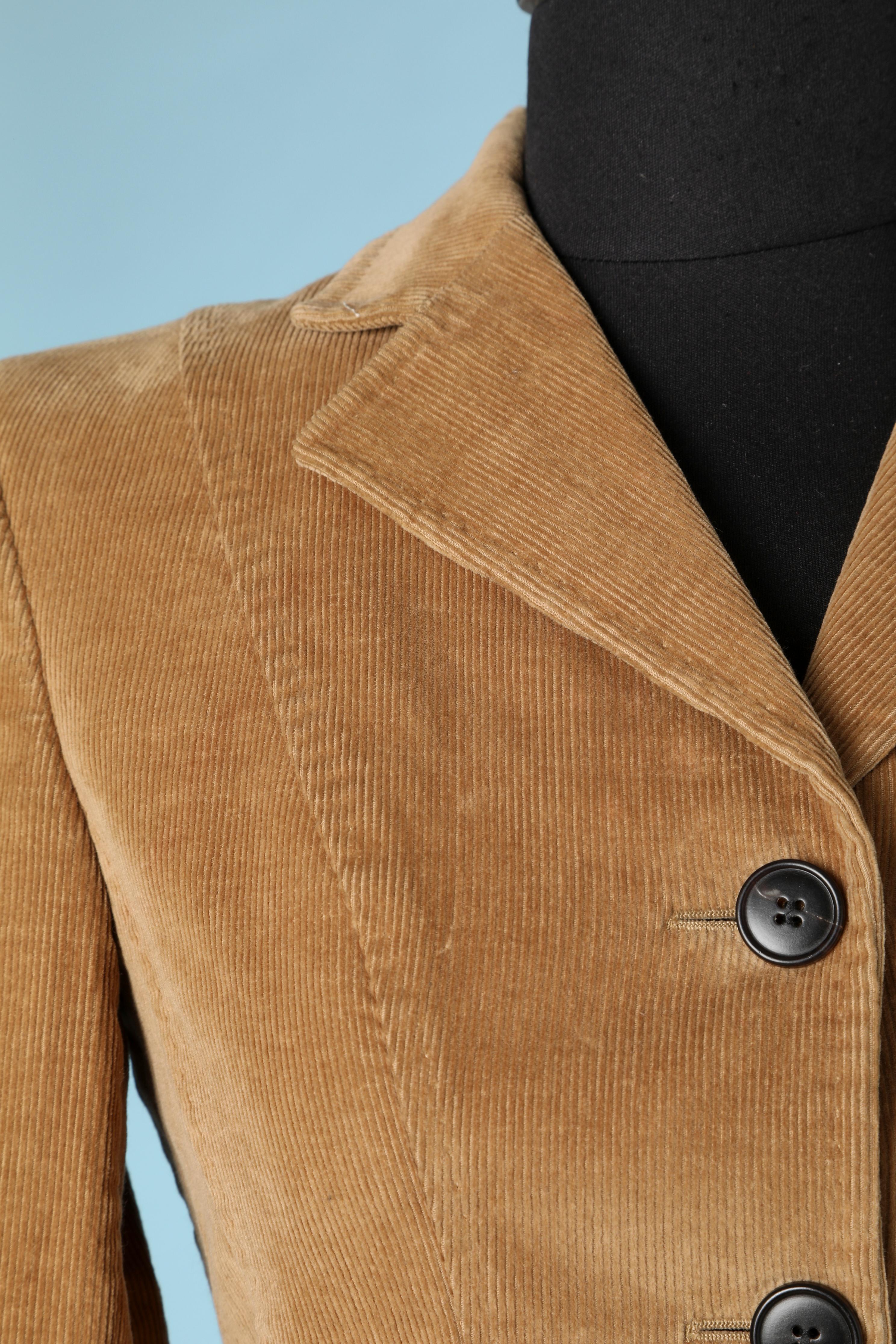 Beigefarbene einreihige Jacke aus Cord. Zusammensetzung des Hauptmaterials: 98% Baumwolle, 2% Lycra . Innenfutter aus Viskose mit Markenzeichen. 
Schulterpolster. Knopf- und Knopflochverschluss in der vorderen Mitte. 
Tasche auf beiden