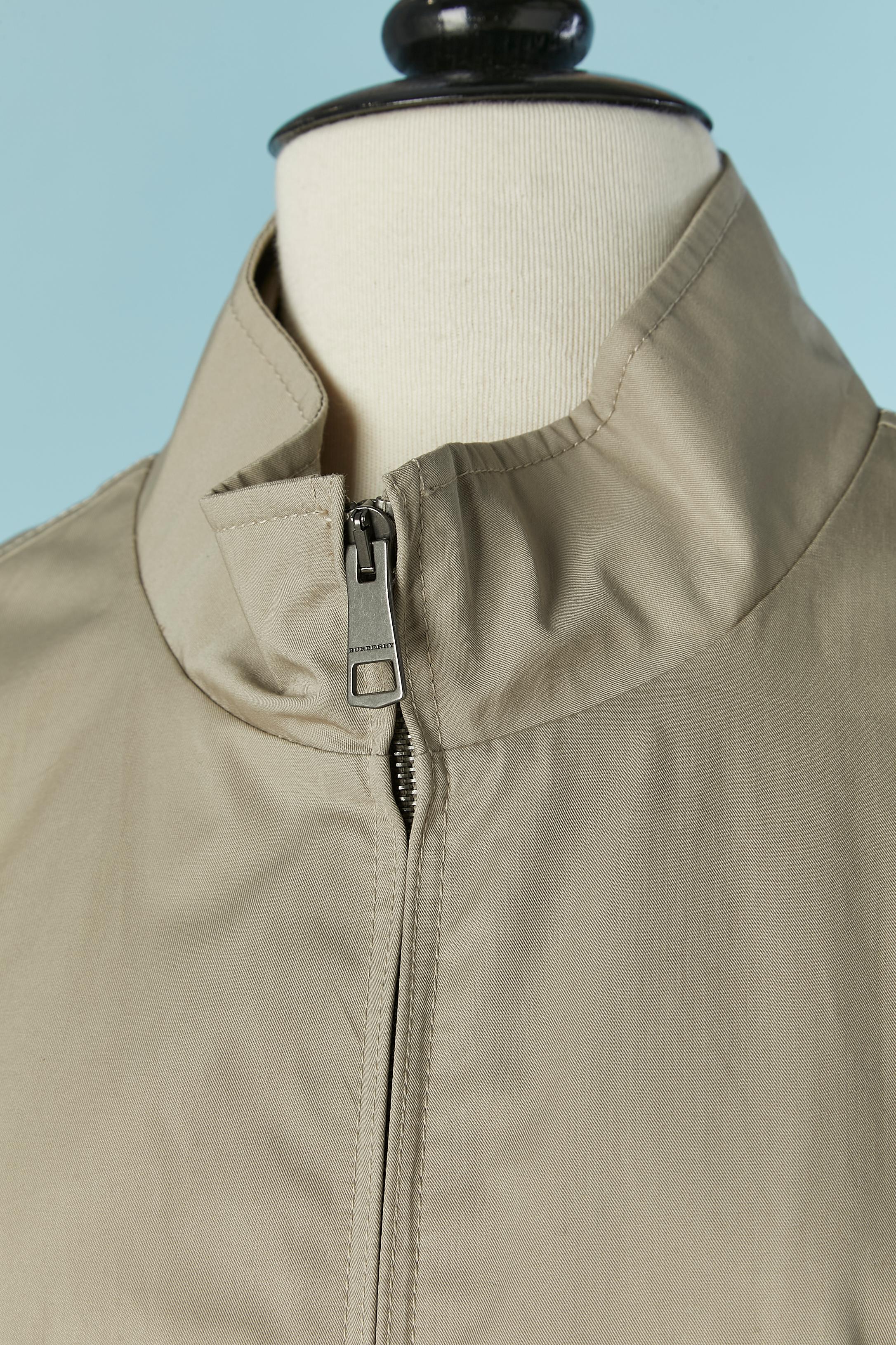 Veste blouson en coton beige. Doublure en coton à carreaux. Fermeture à glissière sur le milieu du devant. Poche sur les deux côtés avec fermeture à glissière. Œillet sous l'aisselle.
TAILLE L 