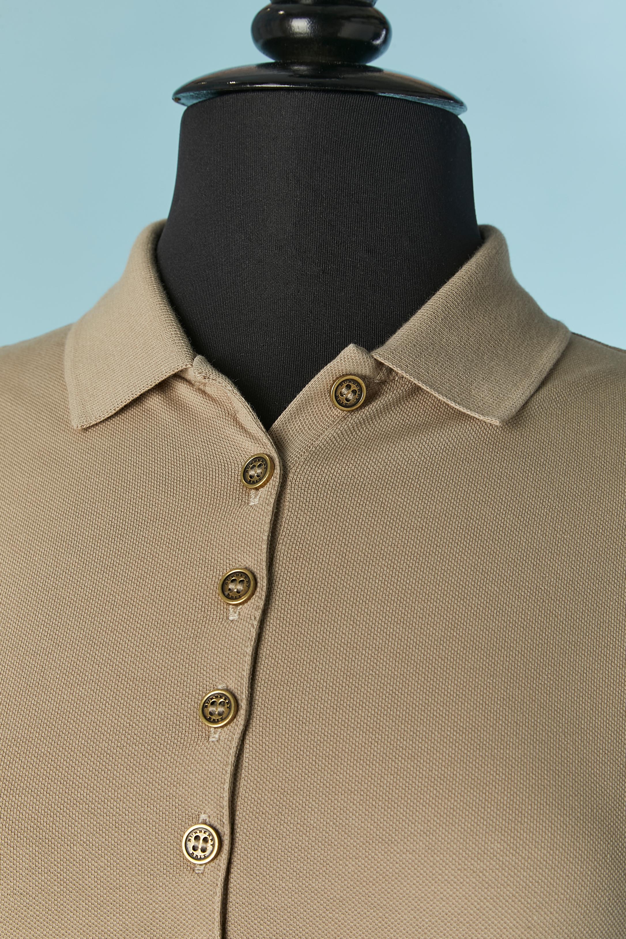 Beigefarbenes Poloshirt aus Baumwolle mit Karomuster und Ballonärmel. Stoffzusammensetzung (beiger Teil): 98% Baumwolle, 2% Elastan. Zusammensetzung des Karostoffs: 100% Baumwolle. Knopfleiste am oberen Ärmelrand und Gummizug am unteren Rand. 