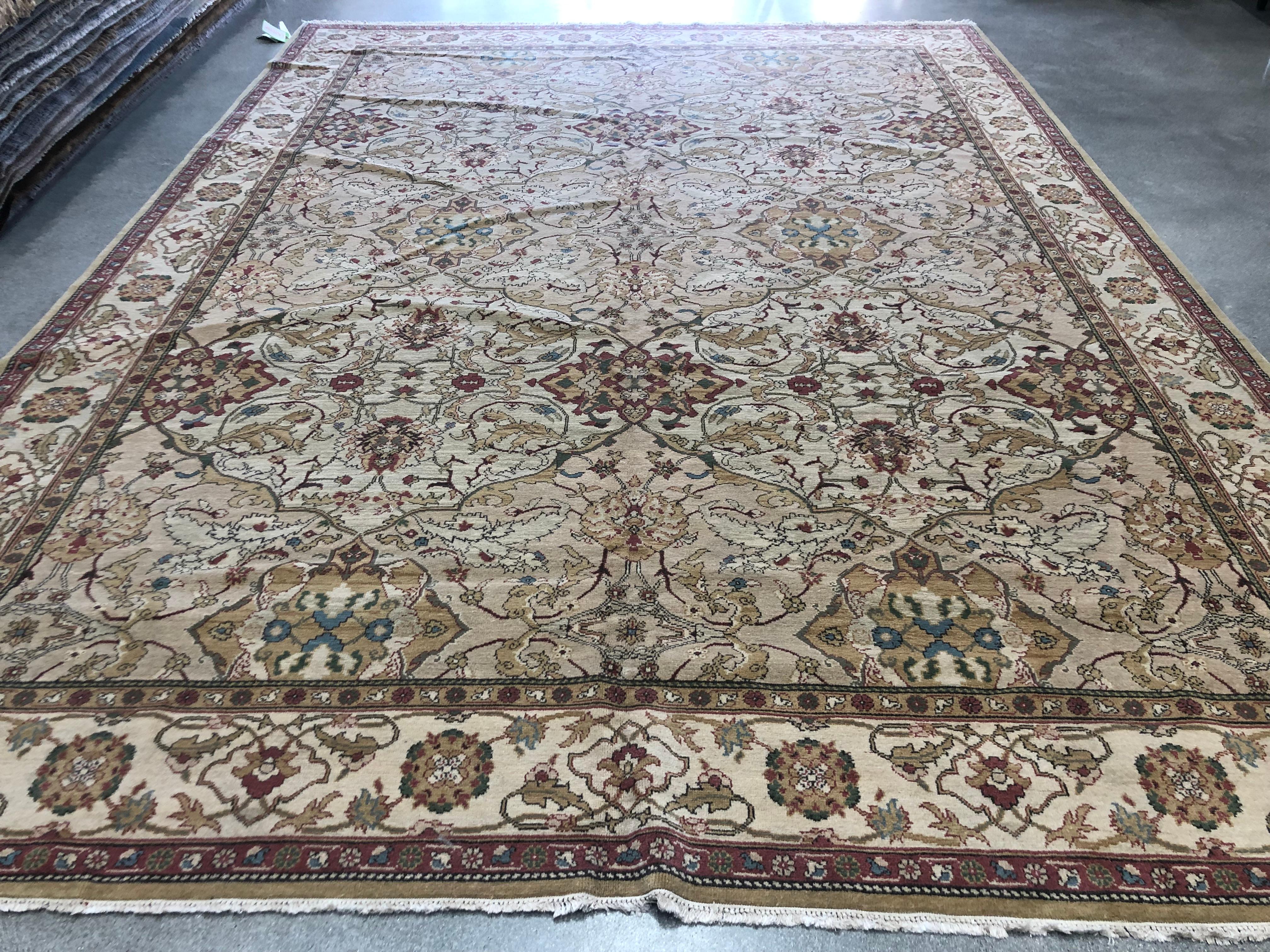 An intricate floral design of red, blue, gold and green lies at the heart of this fascinating area rug. A lighter cream border surrounds and draws attention to the slightly darker beige core with floral ribbons of gold and red tying the spaces