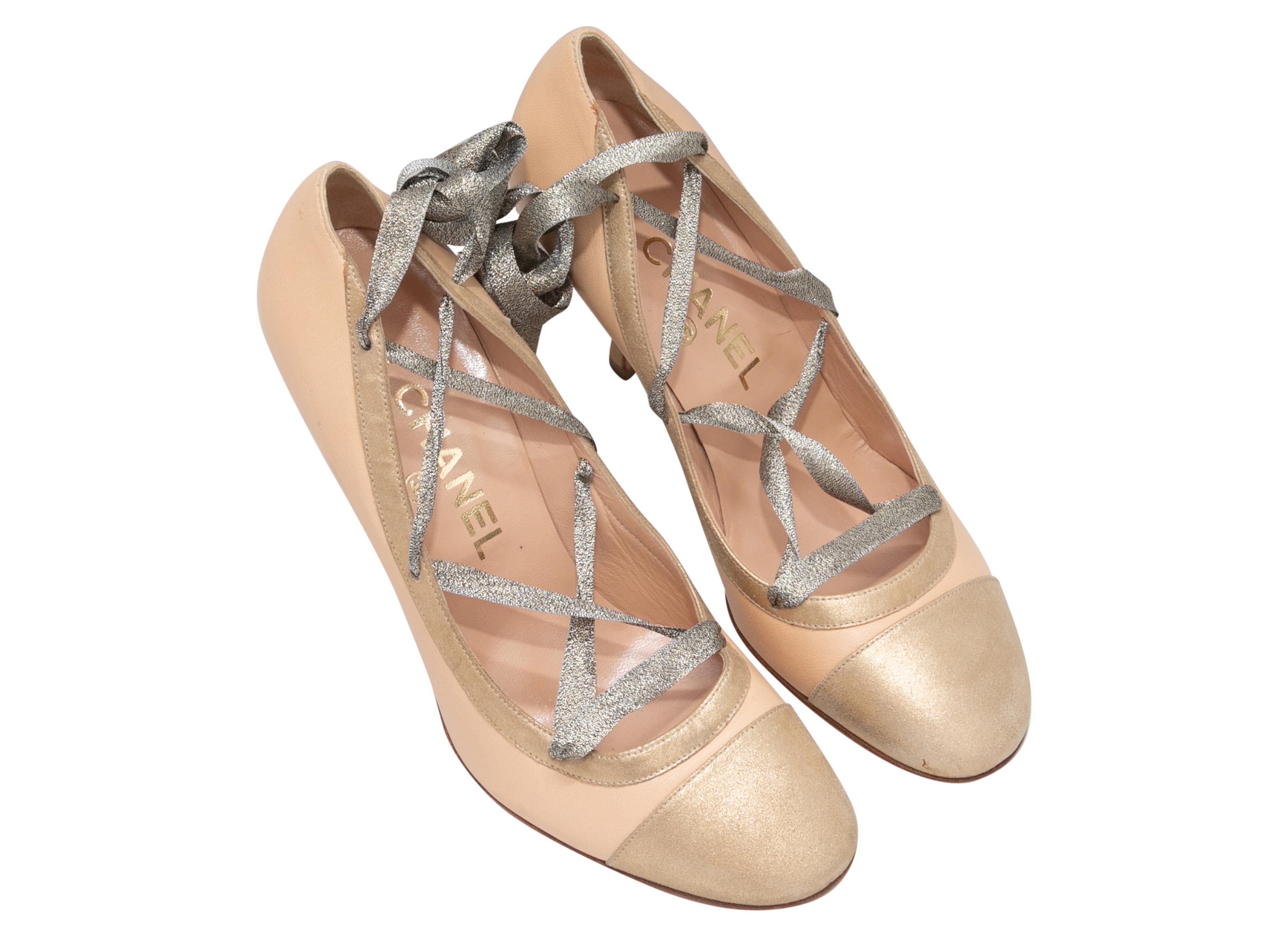 Beige and gold cap-toe lace-up pumps by Chanel. Metallic silver lace-up ties at tops. 3.5