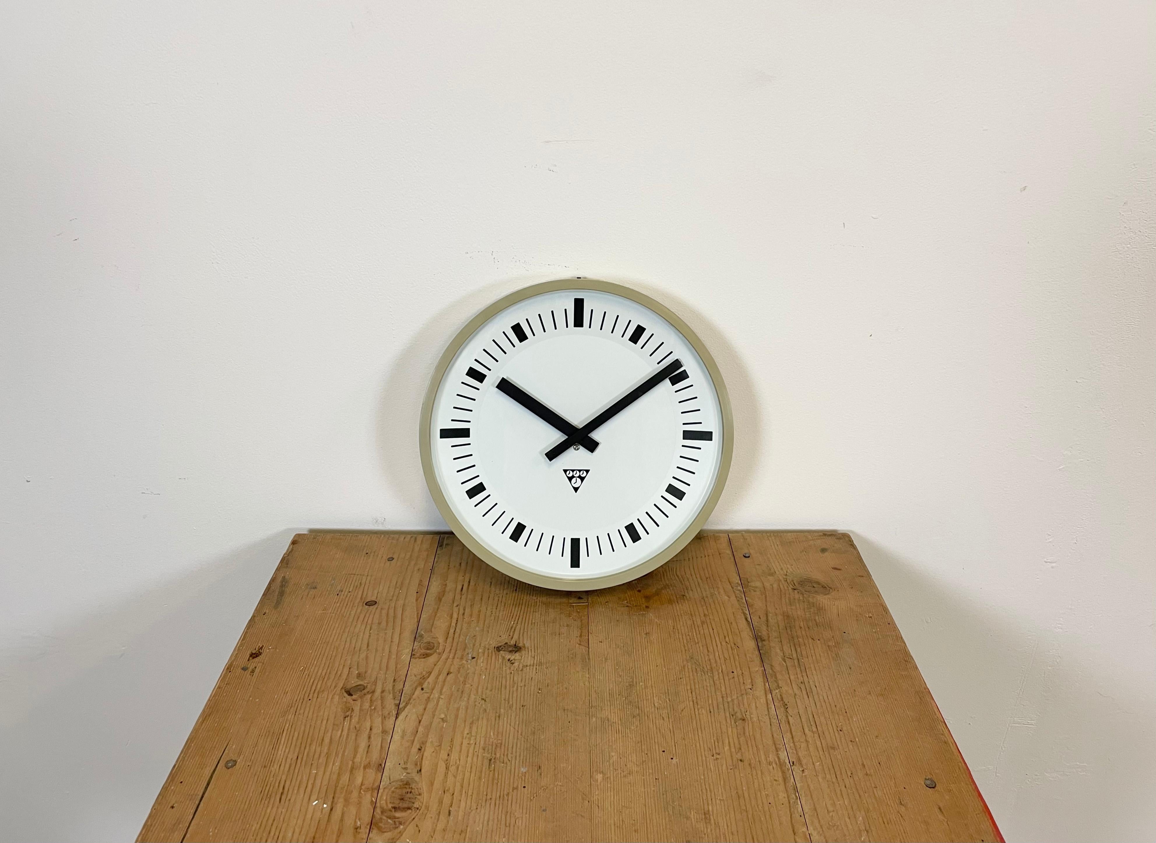 This wall clock was produced by Pragotron in former Czechoslovakia during the 1970s. It features a beige bakelite frame, aluminium dial and clear glass cover. The piece has been converted into a battery-powered clockwork and requires only one