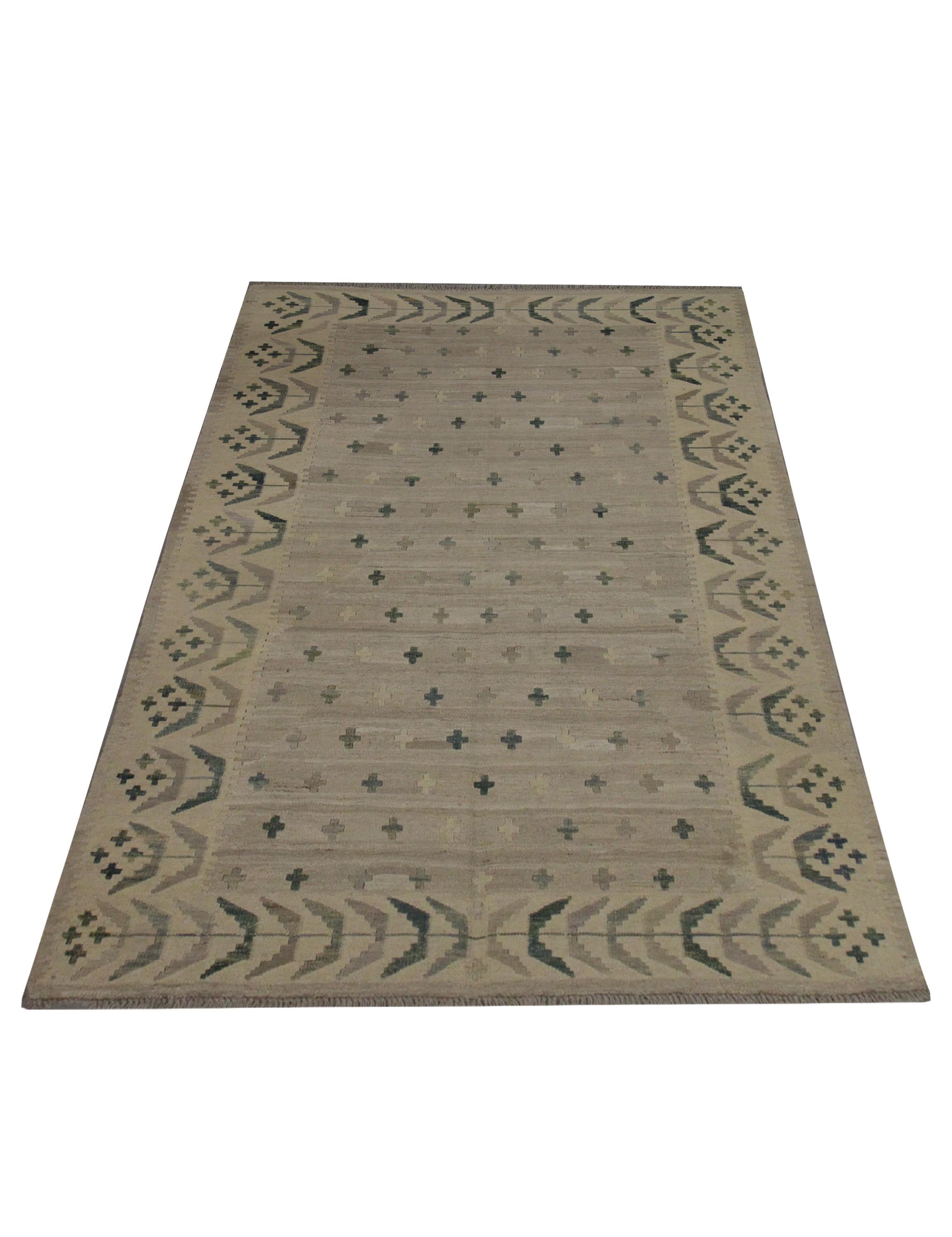 This unique wool Kilim area rug was woven in the early 21st century in Afghanistan. The design features a simple central design featuring a beige open field with Minimalist brown grey and blue cross motifs that are evenly scattered. A traditional