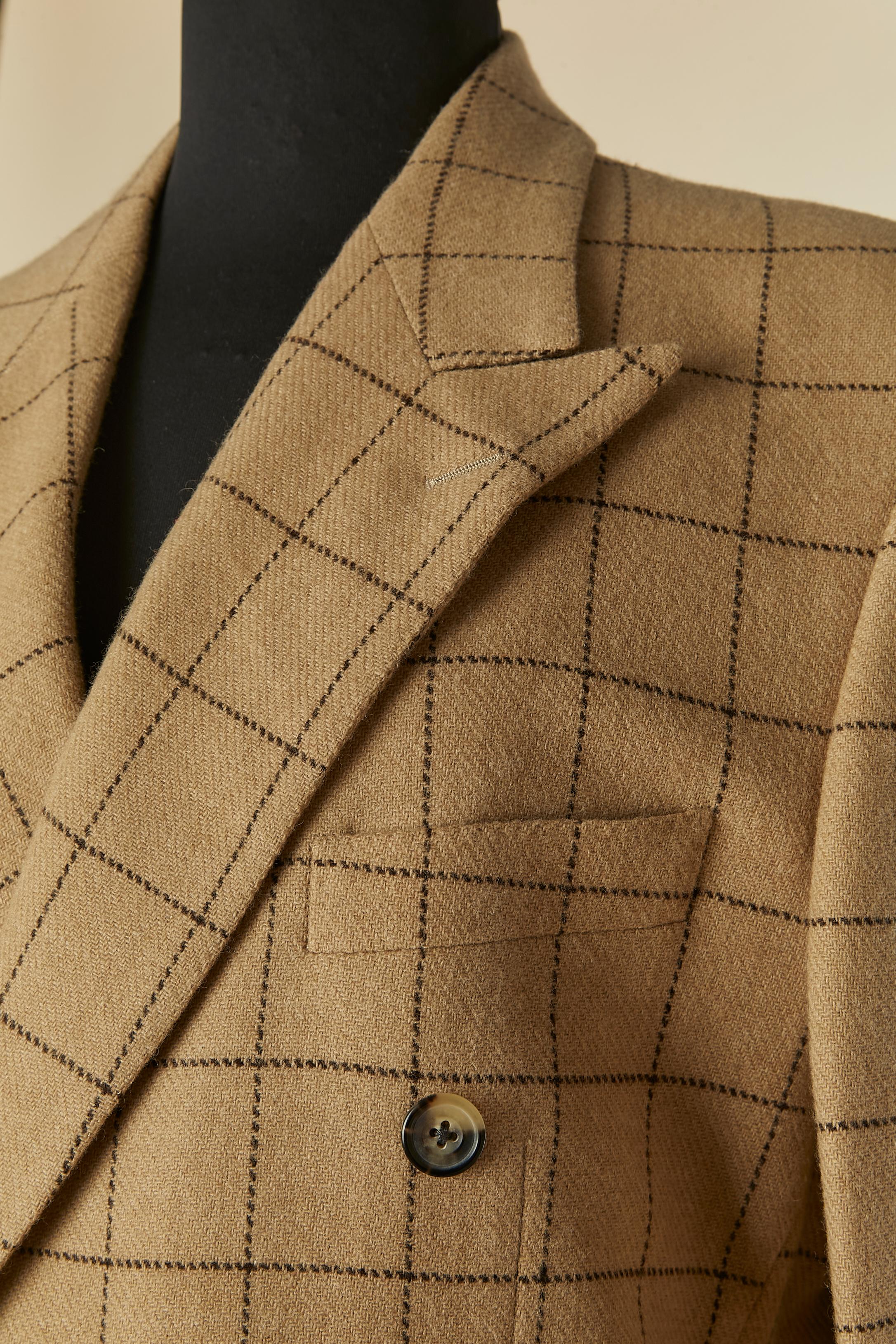 Completo pantalone in lana d'agnello beige con motivo a quadri. Fodera in cupro lilla (solo all'interno della giacca) 
Chiusura con bottoni e asole sul davanti e sui polsini. Pad per le spalle. 2 spacchi sul lato posteriore, lunghezza= 27cm
4 tasche