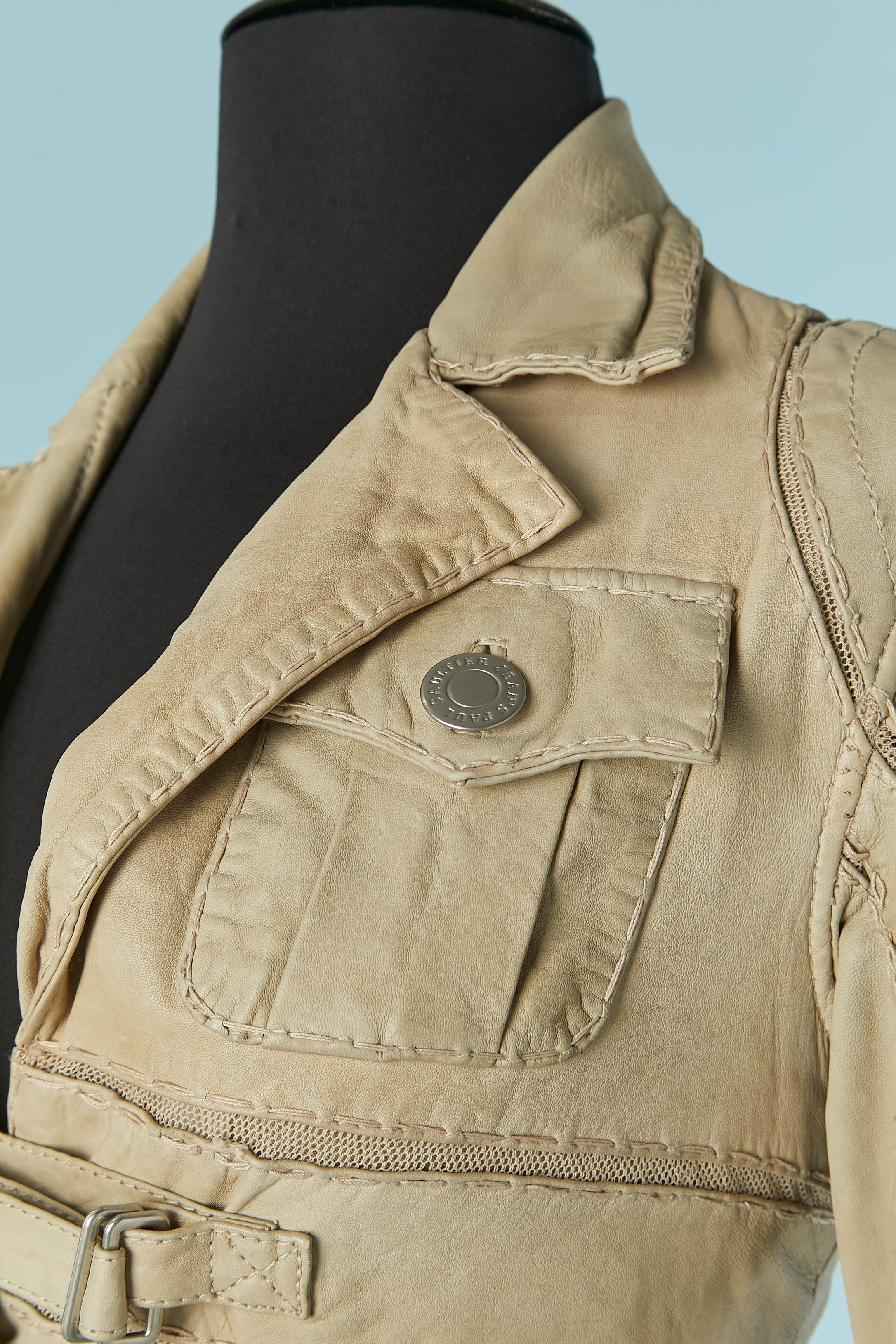 Beige leather single breasted jacket with top-stitching and tulle inset. 
Cotton lining. Branded button and buttonhole closure on the middle front and on the pocket. Leather strap with buckle closure on the middle front and on the cuffs. 
SIZE 40