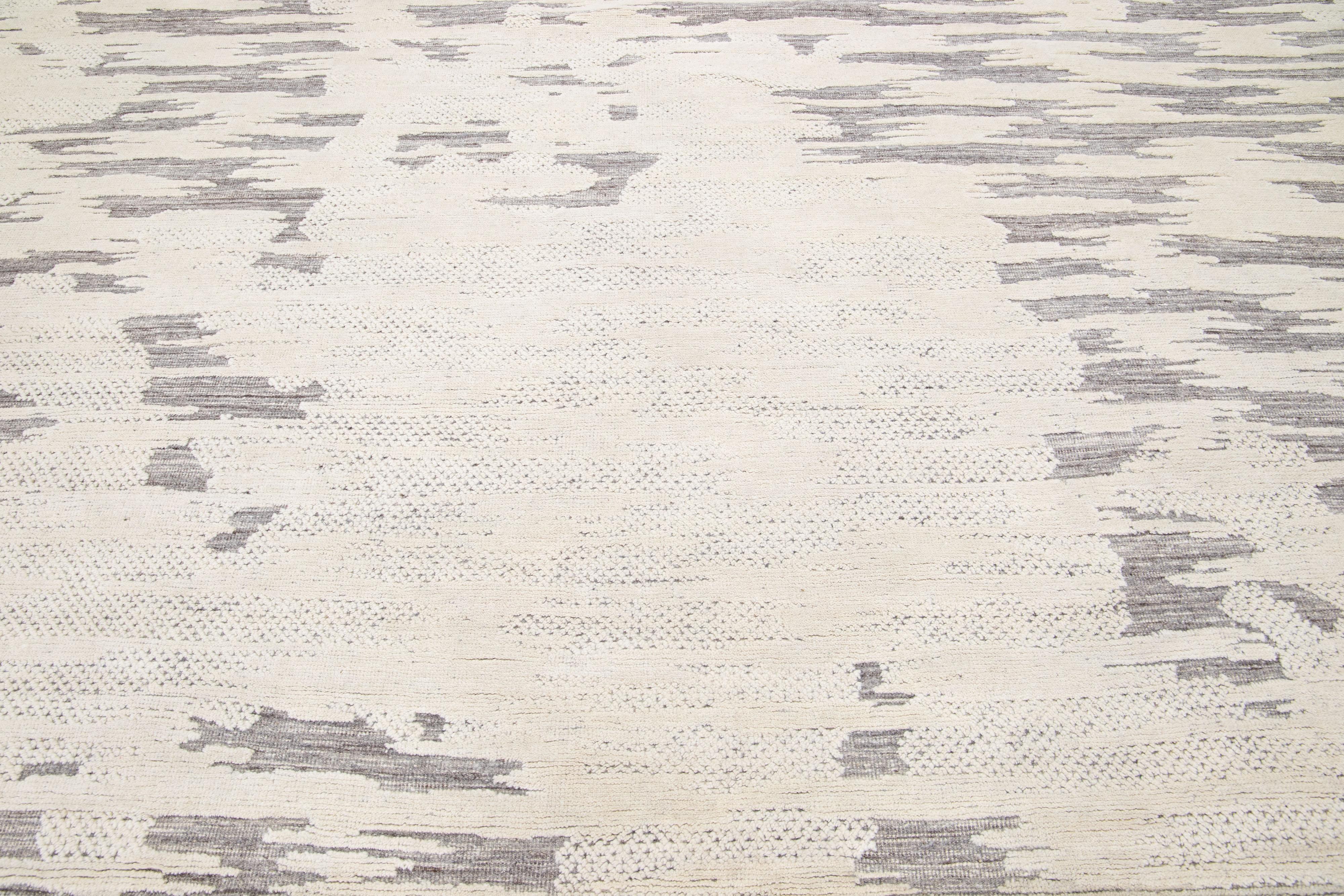 Beautiful modern Moroccan-style hand-knotted wool rug with a beige and ivory color field. This rug is part of our Apadana's Safi Collection and features a minimalist design in gray.

This rug measures: 10'3