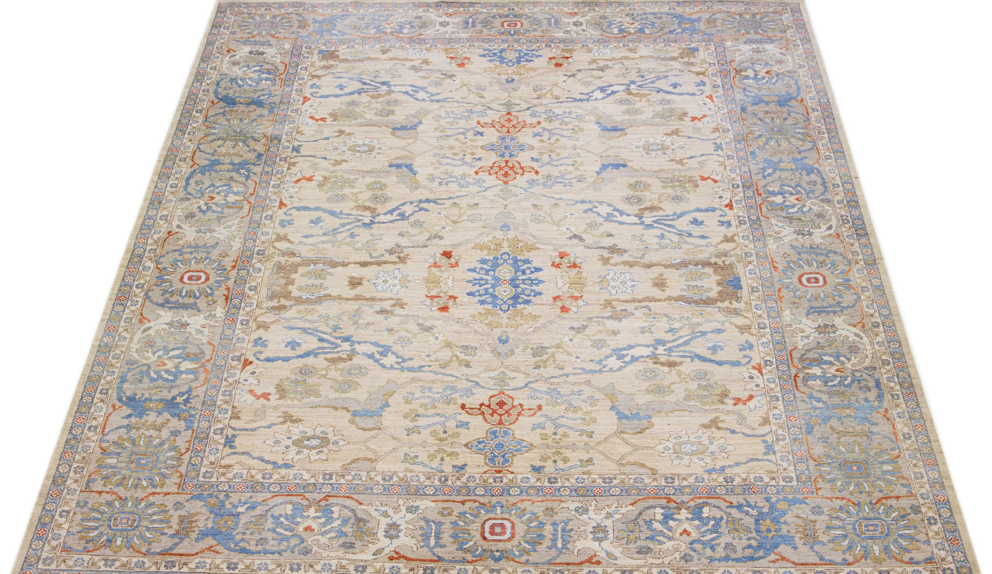 This hand knotted wool rug showcases an exquisite modern Oversize Oushak Style design in a stunning beige color palette. Its intricate frame features captivating accents in rust, blue, and brown hues arranged in a remarkable all-over