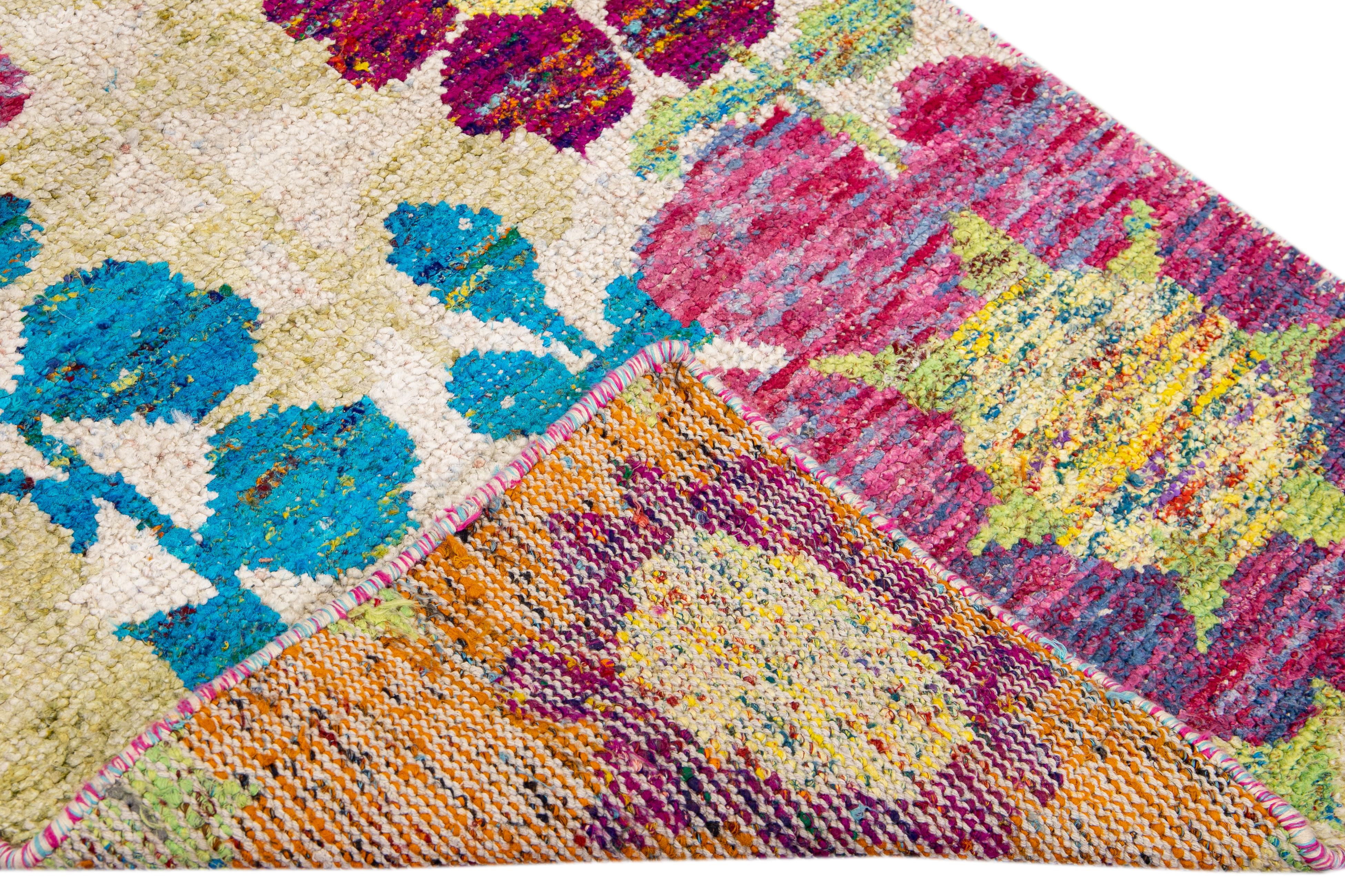 Schöner moderner indischer handgeknüpfter Wollläufer mit beigem Feld. Dieser moderne Teppich hat orange, gelbe, grüne und blaue Akzente und ein wunderschönes geometrisches, florales Muster.

Dieser Teppich misst: 3'1